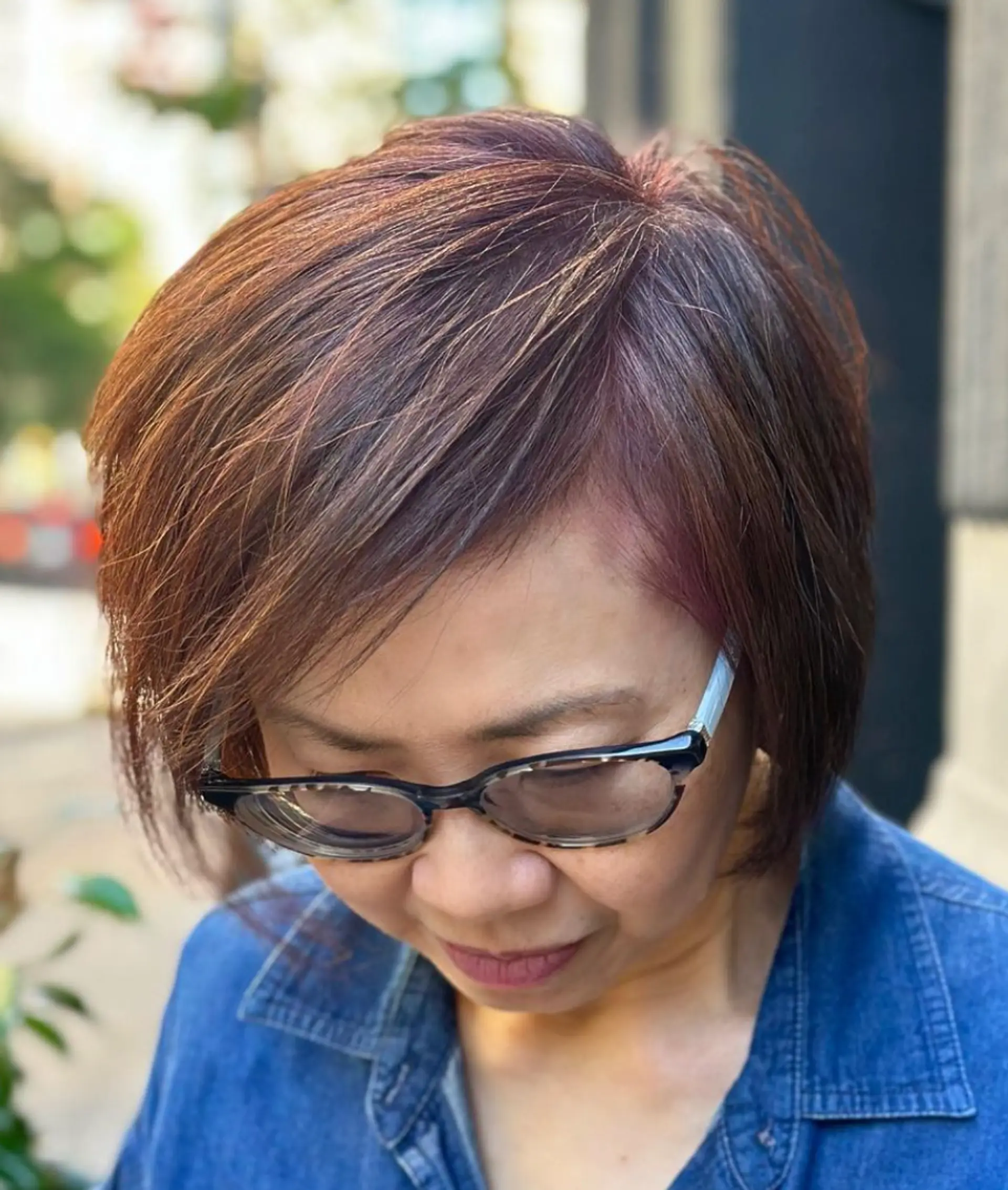 Short, precisely layered dark brown hair with subtle red highlights, side-swept bangs, and a smooth finish. Ideal for a sophisticated, modern look.

Color by @simabeautynyc
 2