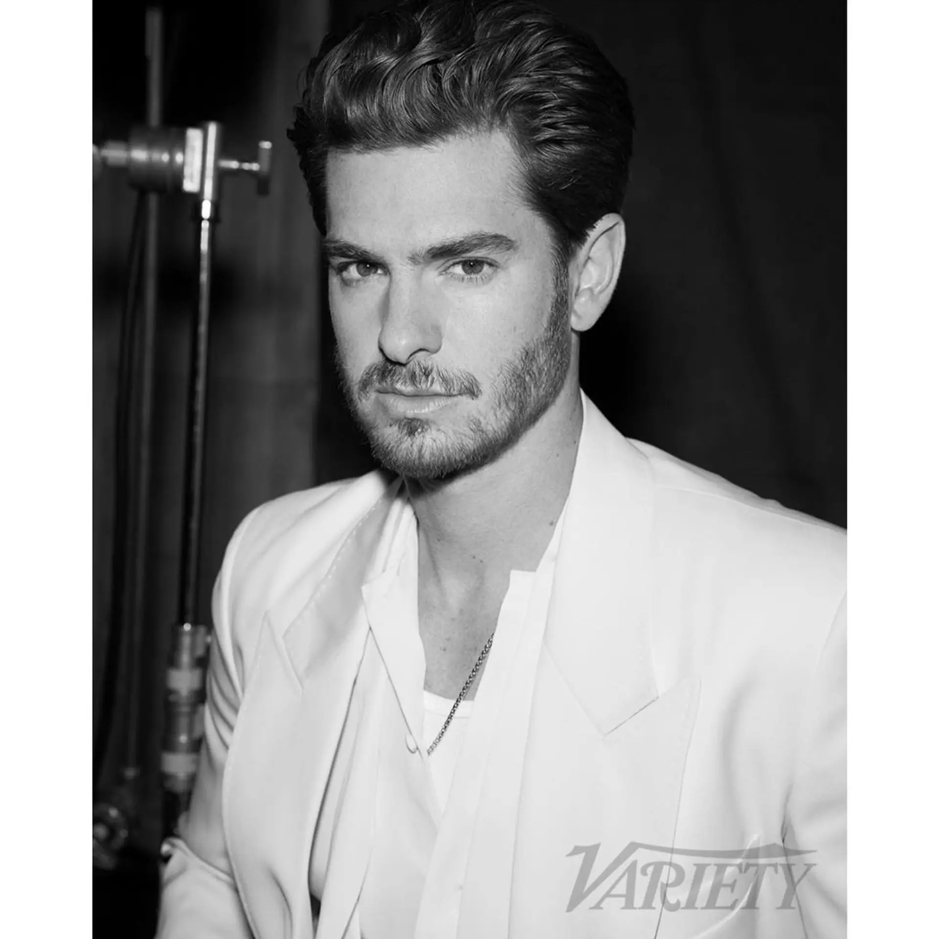 A sophisticated short cut styled with high volume and swept back off the forehead, complemented by clean tapered sides and groomed facial hair. 1