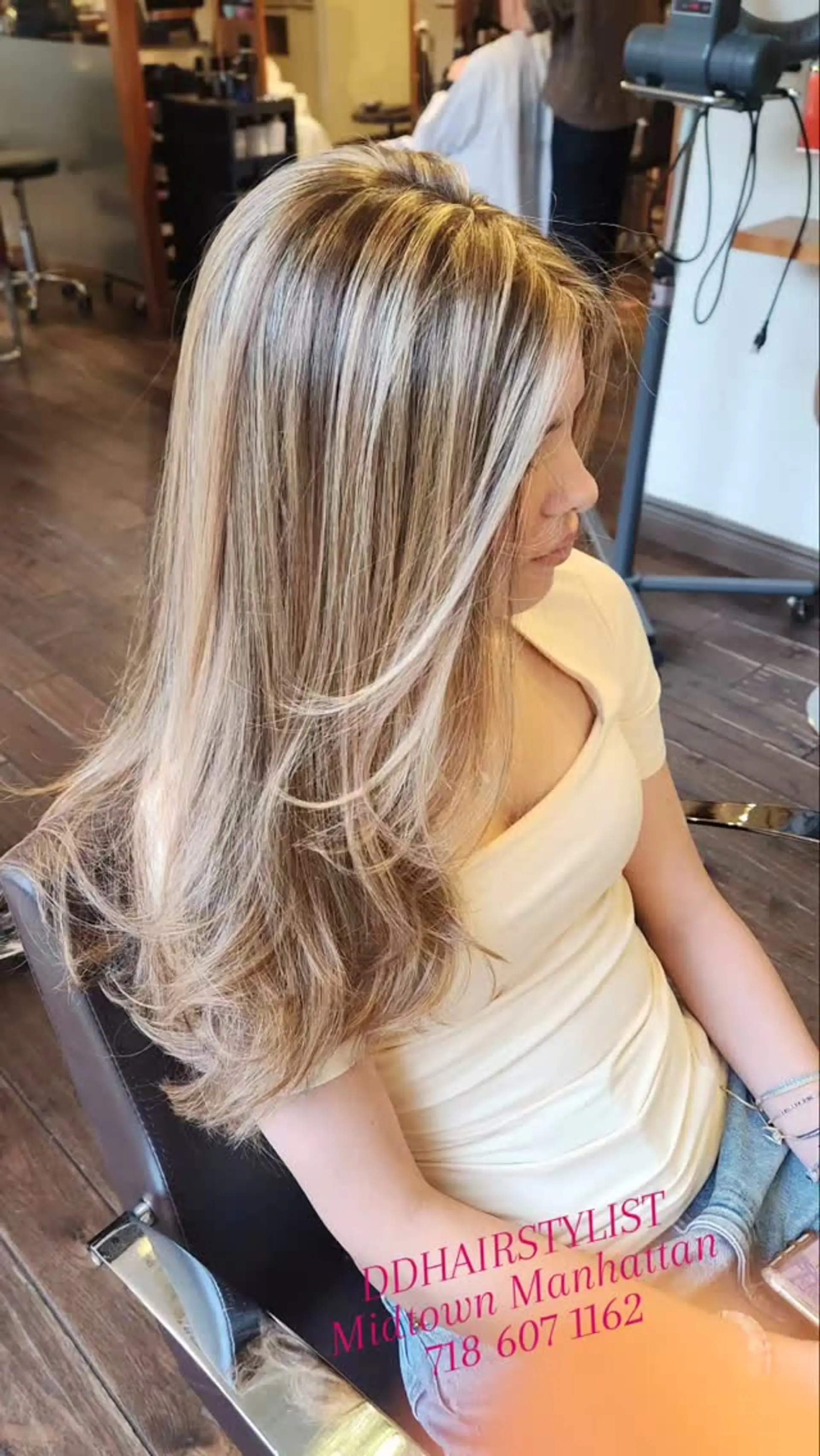Long multi-dimensional blonde highlighted hair styled with smooth face-framing layers and curled ends. 1