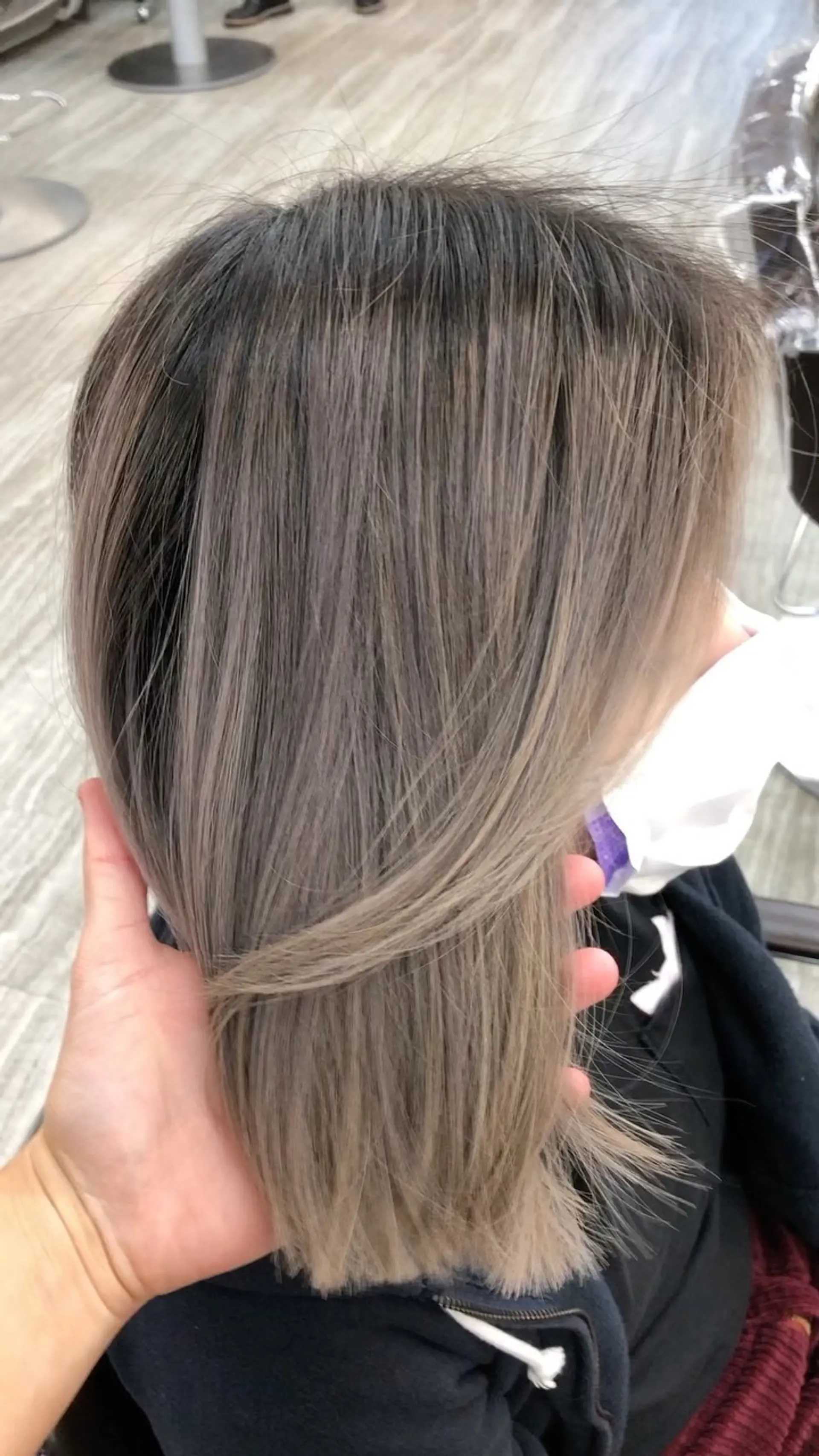 A sleek, shoulder-length blunt cut featuring a seamless cool-toned ash brown and beige-blonde color melt. 1