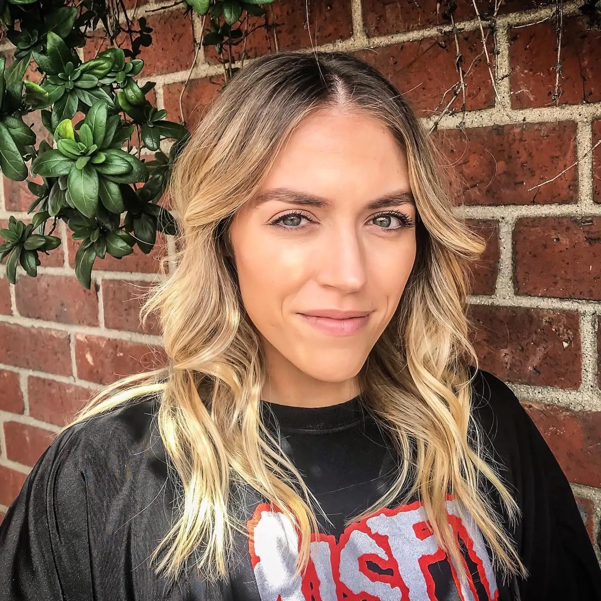 Medium-length blonde hair styled in soft, loose waves with a center part and subtle layers. 1