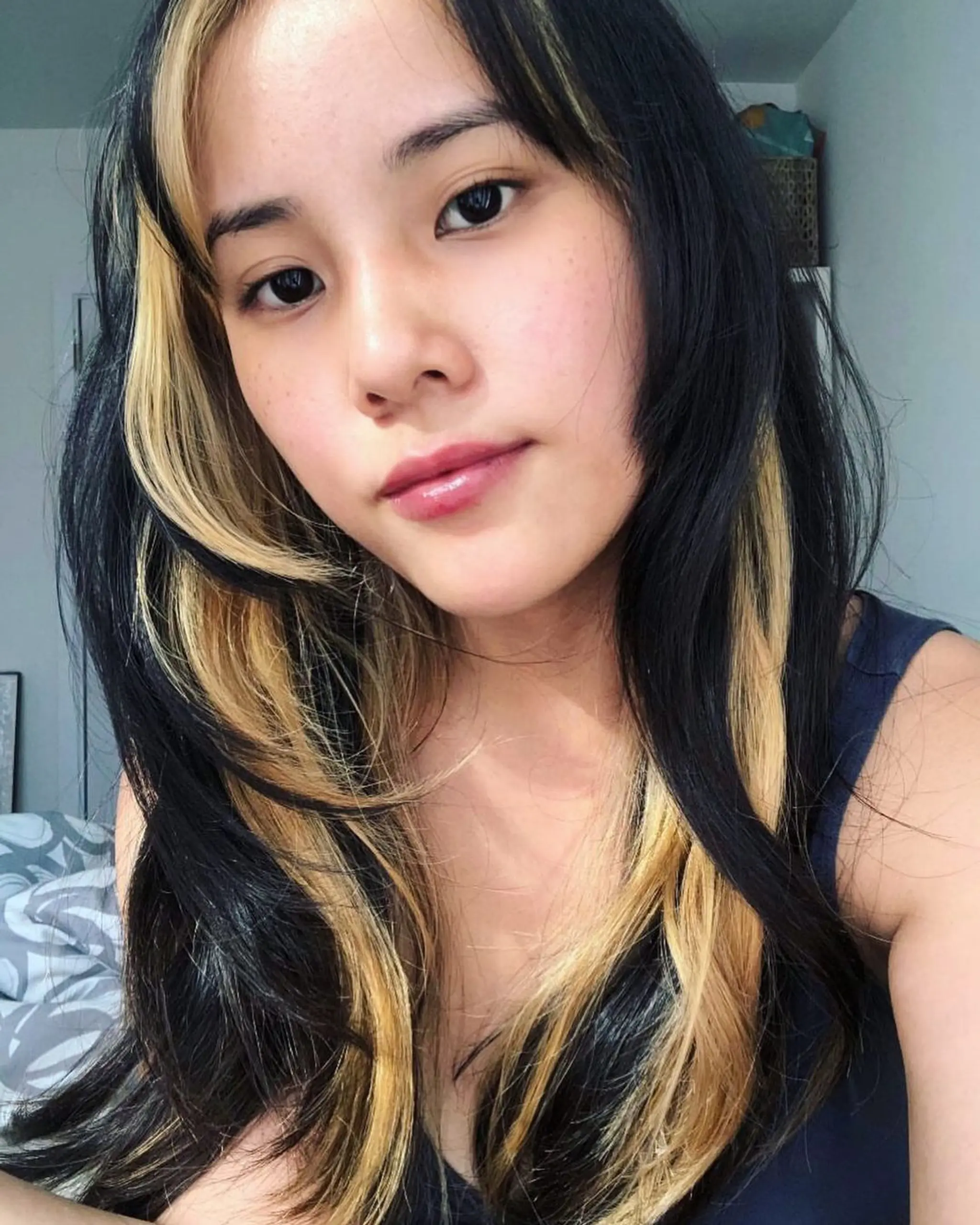 Long hairstyle with black and blonde dual-tone color, featuring face-framing highlights.