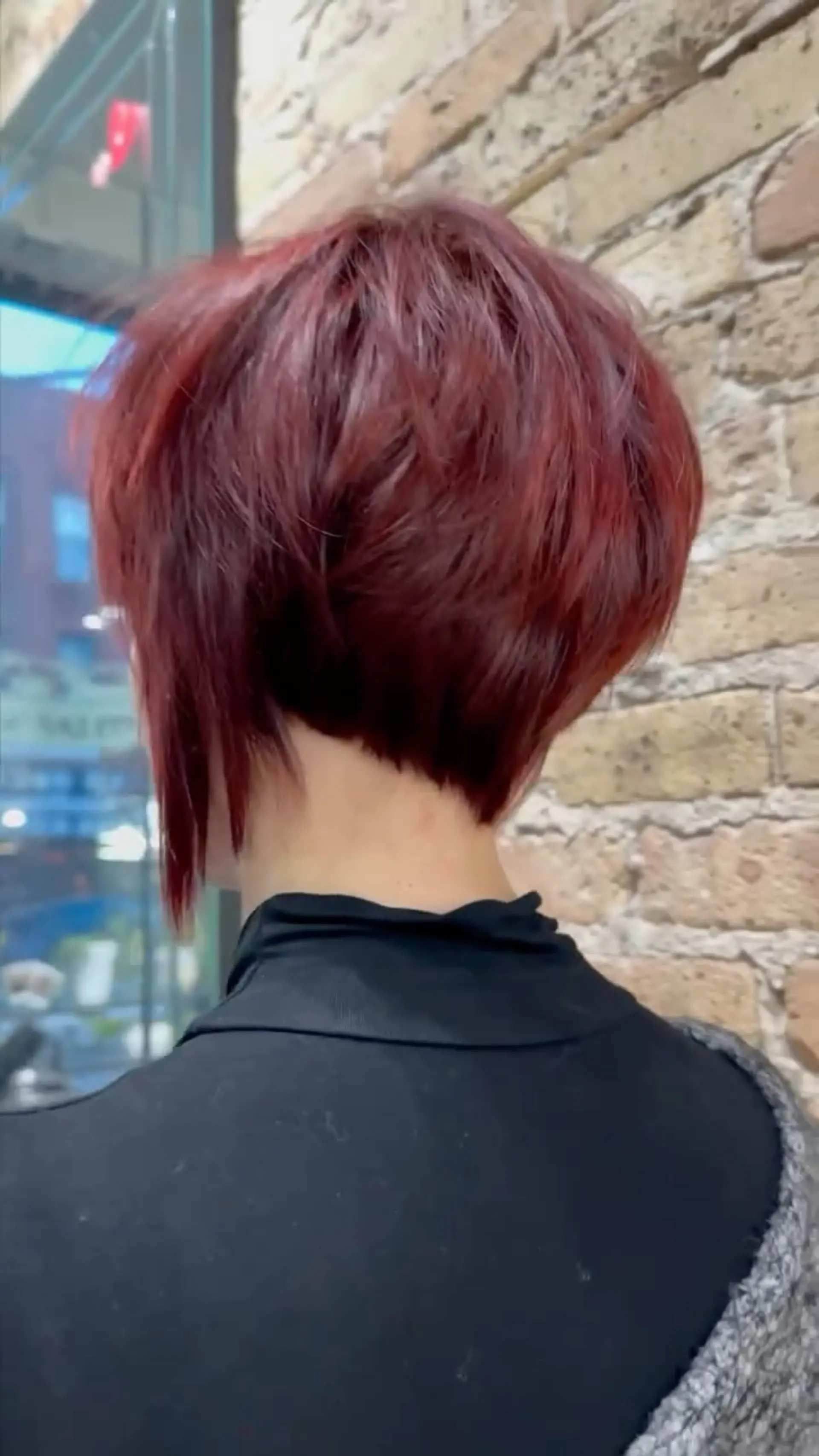 A bold, short asymmetrical pixie bob with a clean tapered nape, crown volume, and vibrant red coloring. 1