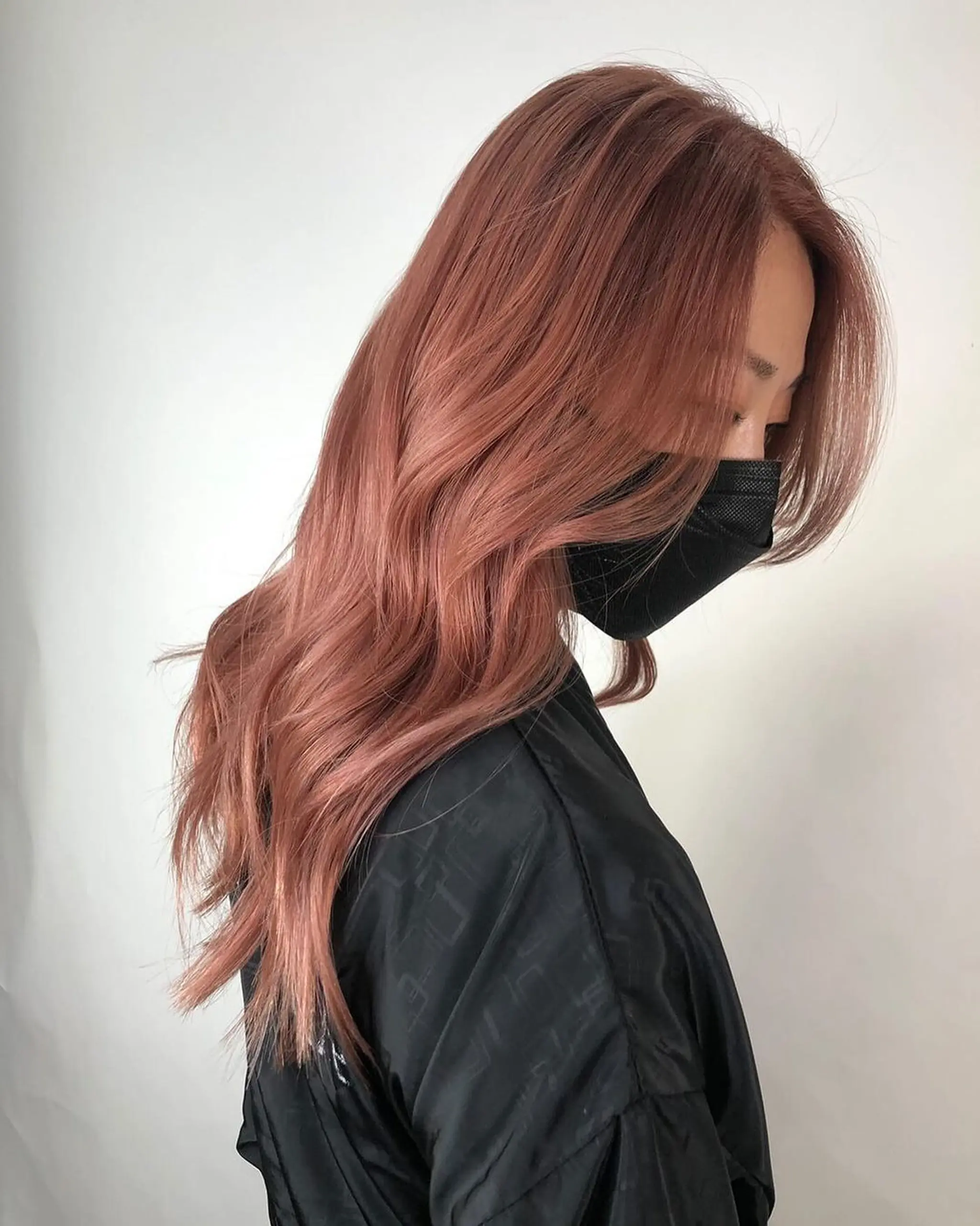 Long, wavy hair with a side part, characterized by a rose gold and copper hue. The style features soft waves and face-framing layers, adding natural volume and shine.
Stylist - @xcellent_jason