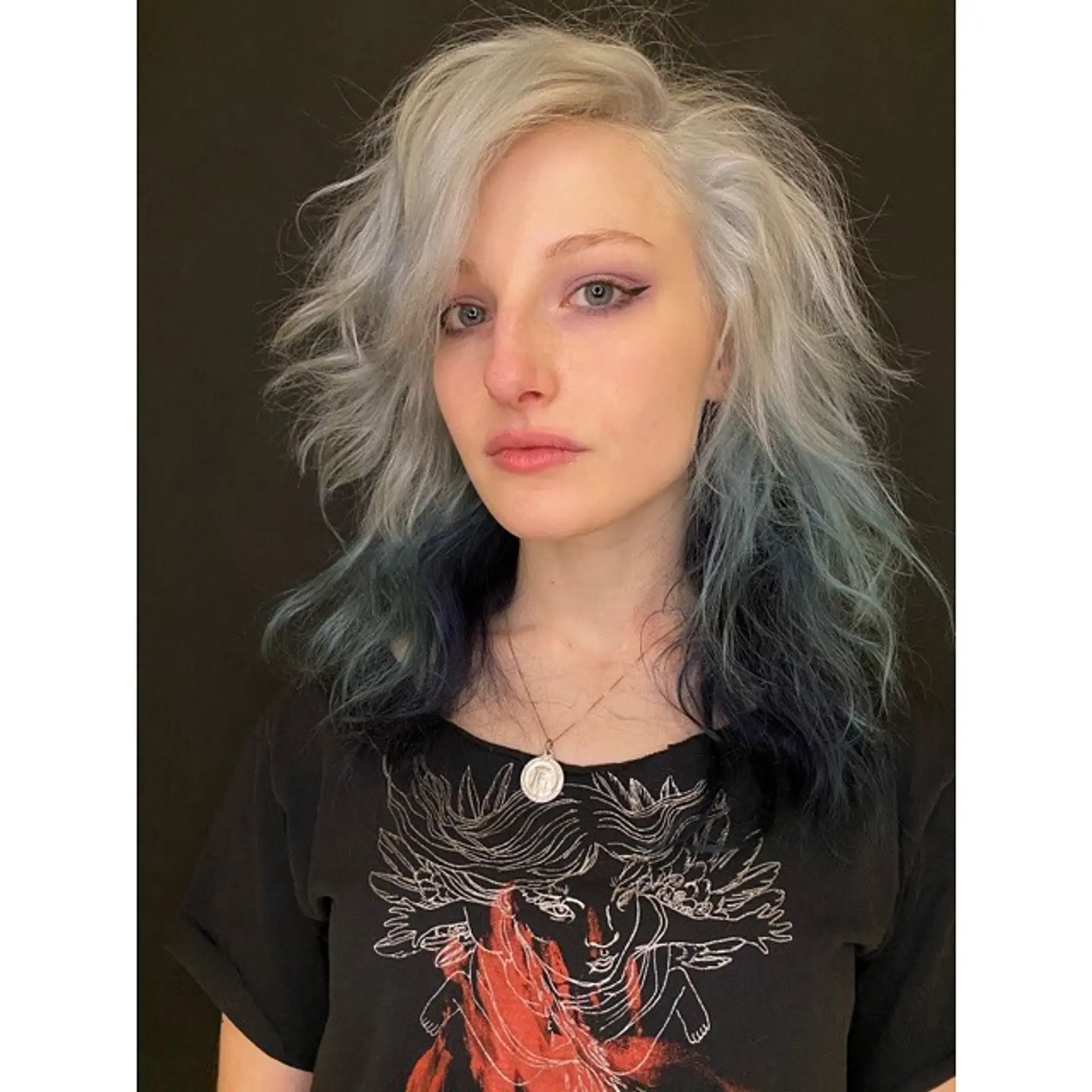 An edgy, medium-length wavy hairstyle with an icy blonde and blue ombre color. 1