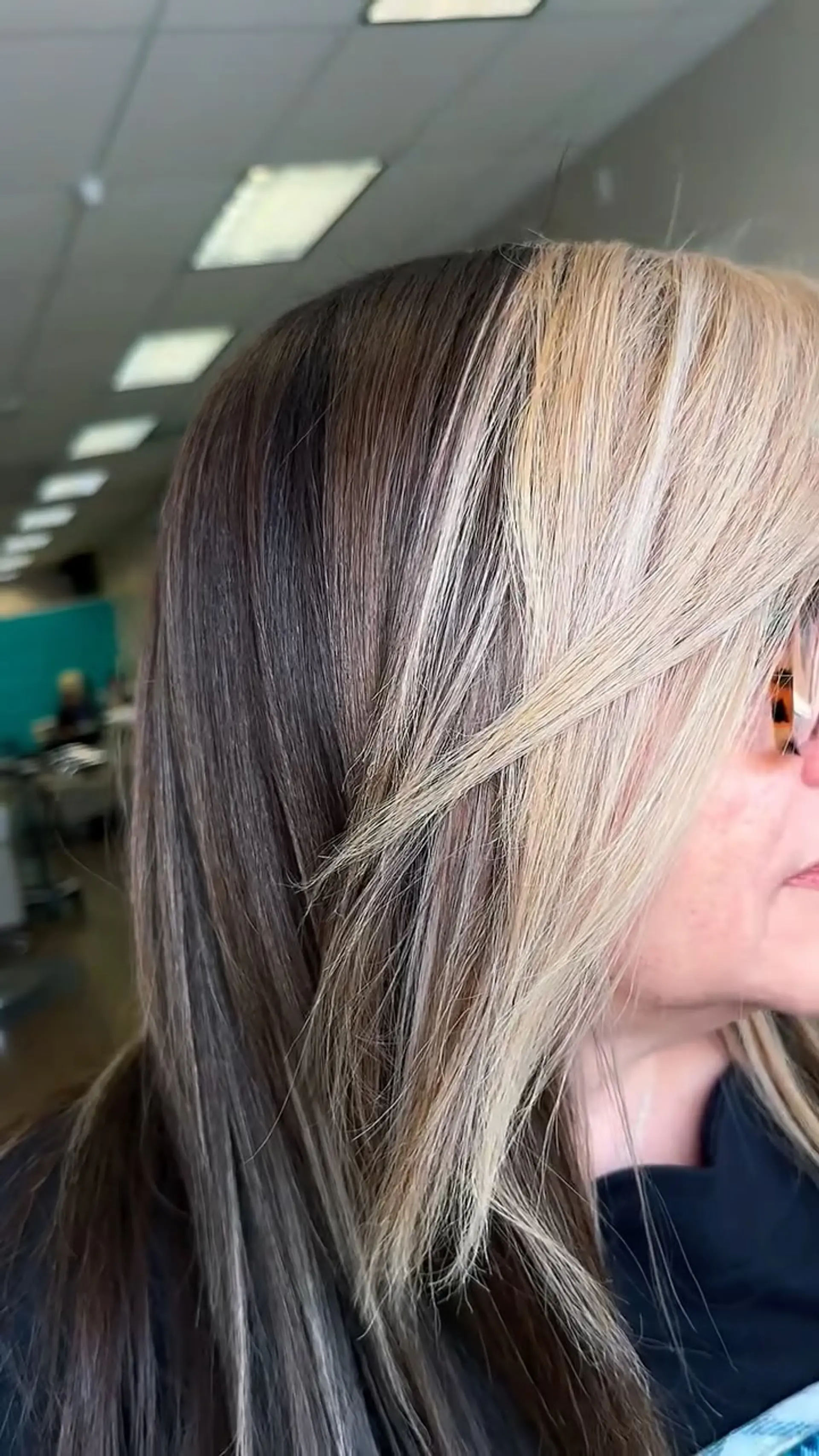 A sleek, straight medium-length style featuring bold blonde face-framing money piece highlights contrasted against rich brunette base hair. 1