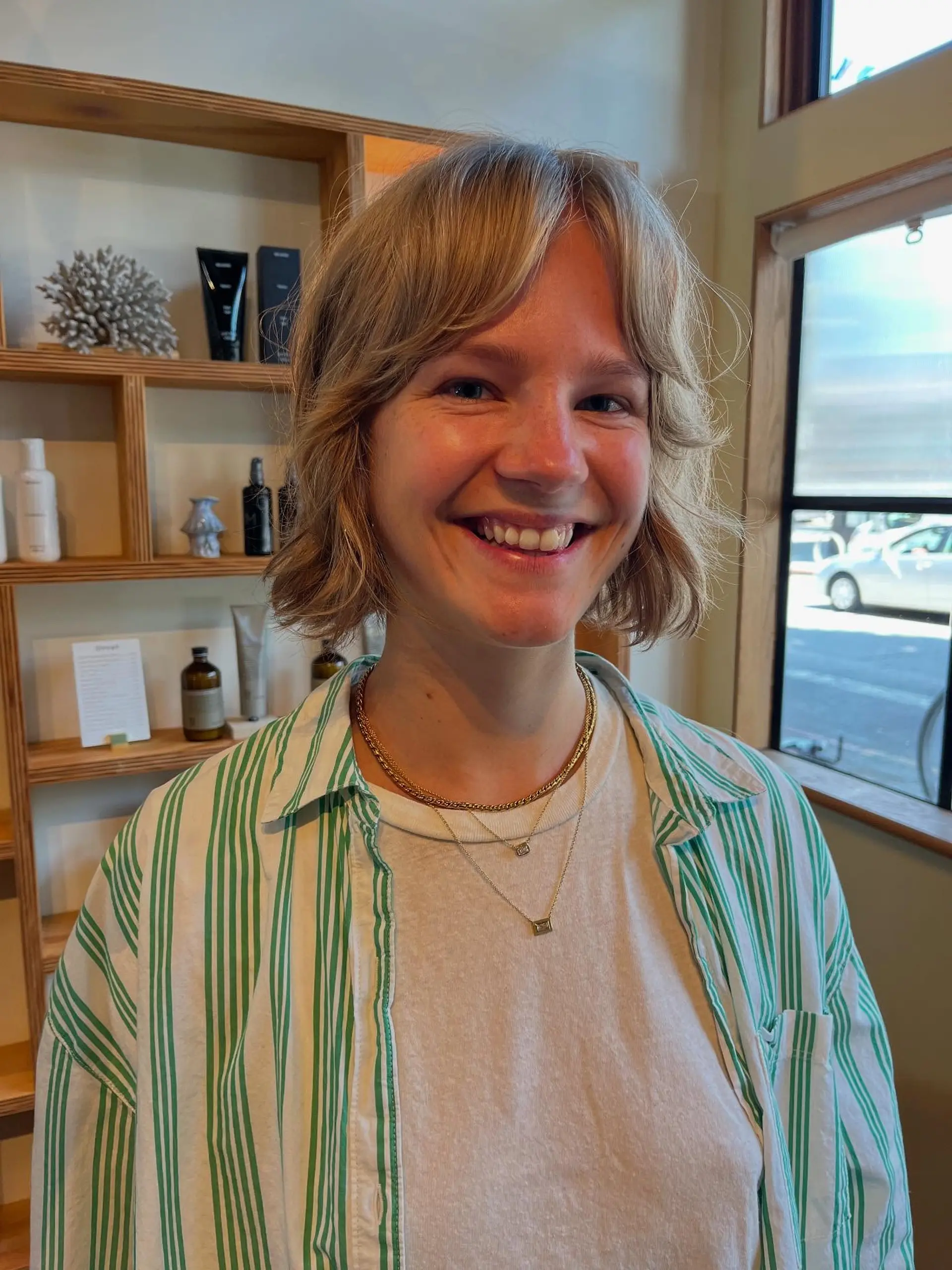 A short, airy bob haircut featuring face-framing curtain bangs and gentle wavy texture. 1