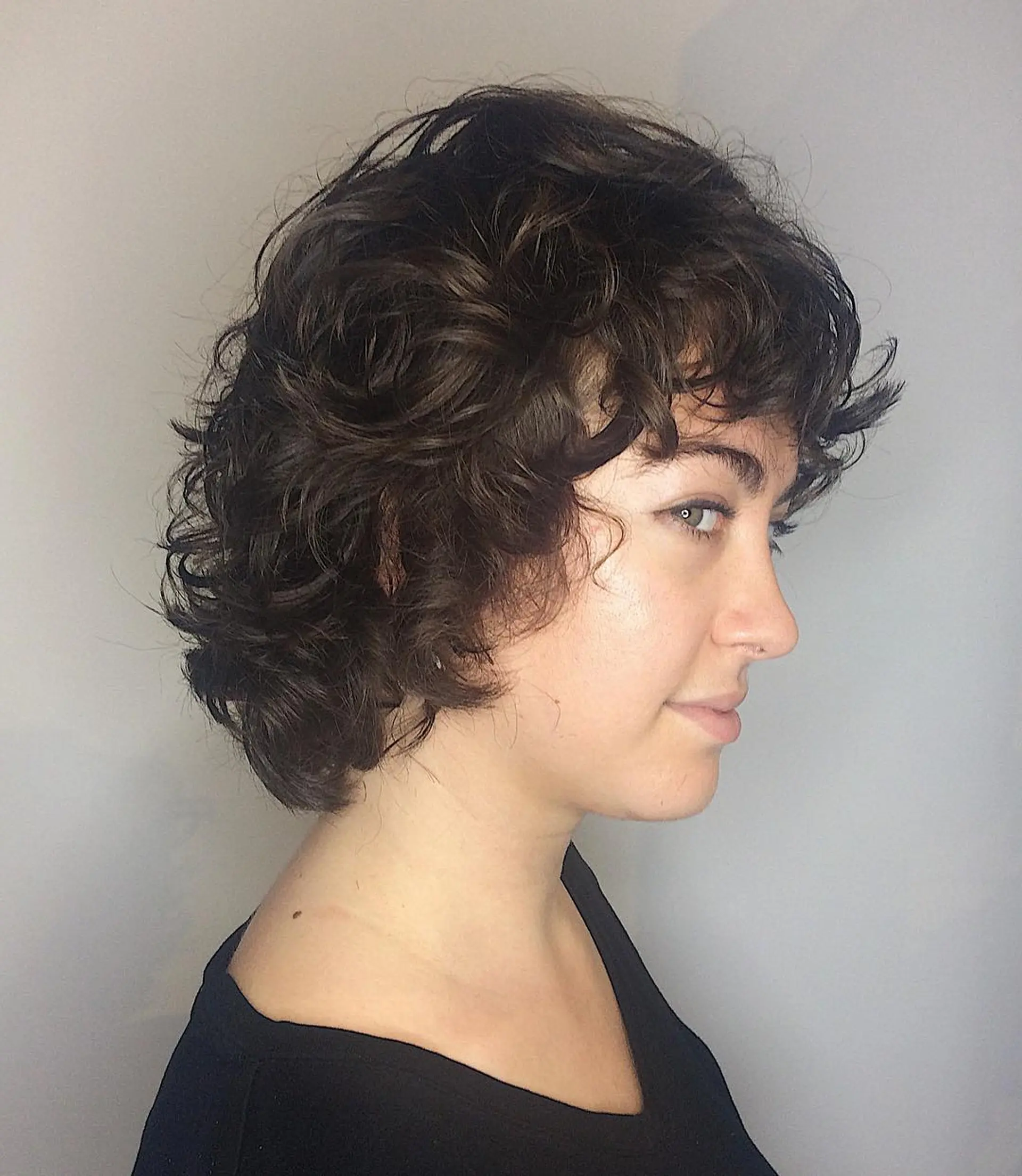 A short, textured curly bob with a fringe. 1