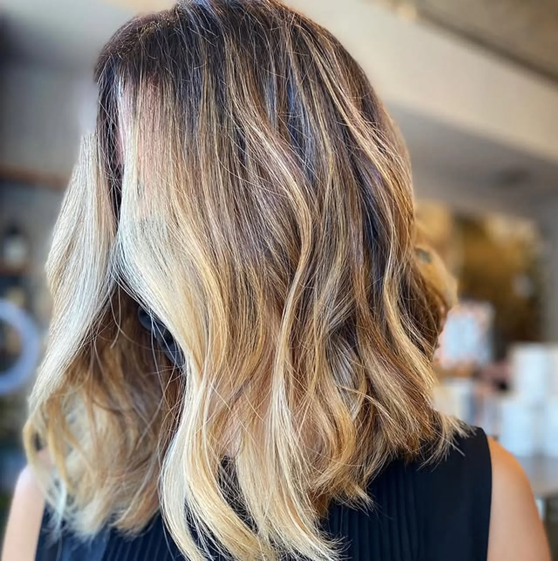A medium-length wavy hairstyle with a bronde balayage color. 1