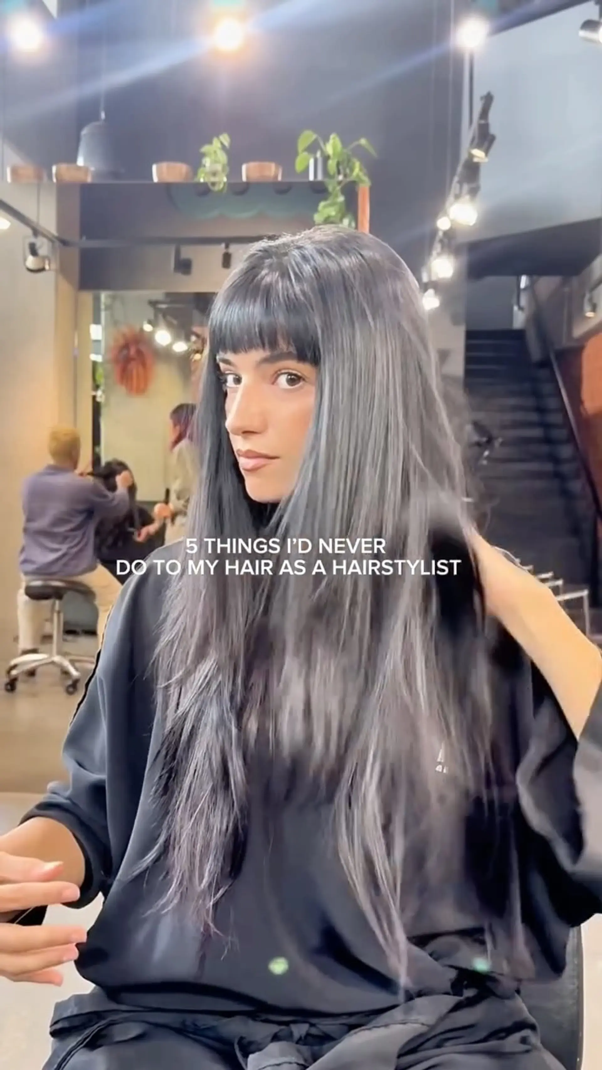 Long straight hair in a cool smoky charcoal grey tone, featuring blunt straight-across bangs and soft textured layers. 1