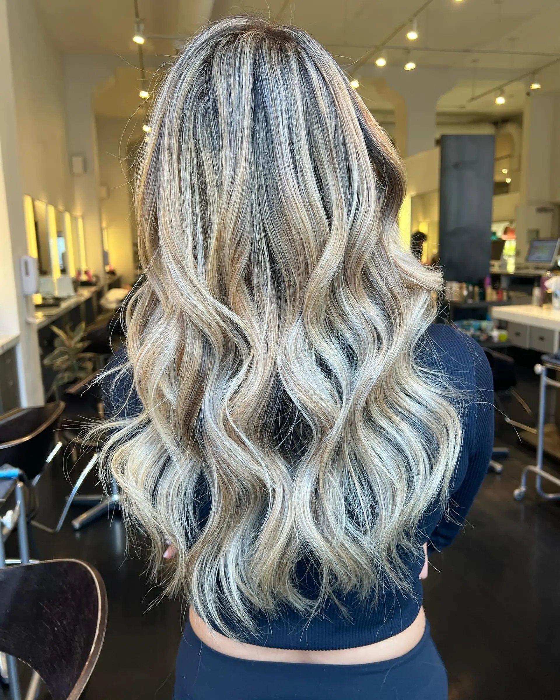 Long layered hair styled with loose, flowing waves and multi-dimensional ash and platinum blonde highlights. 1