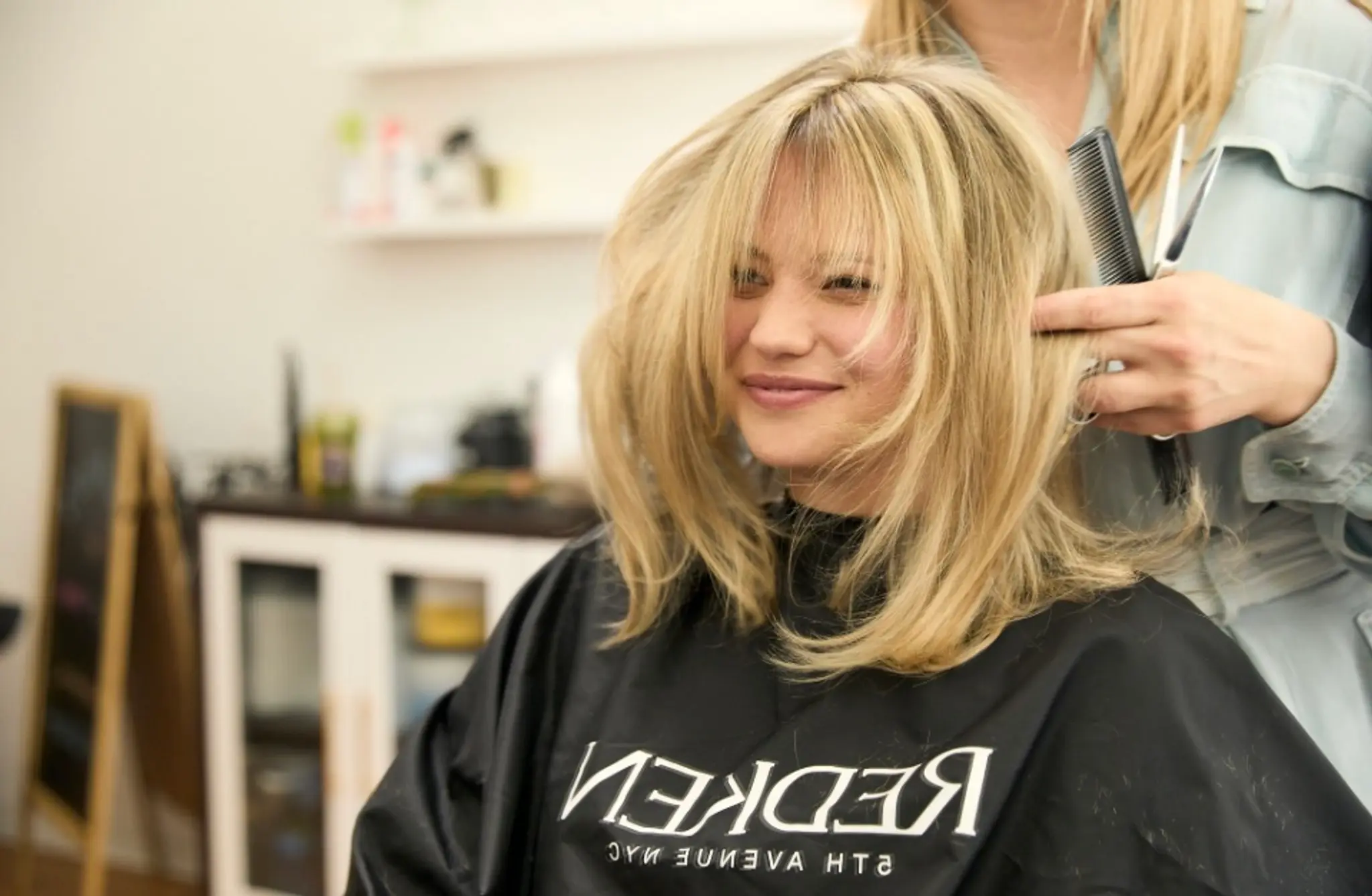 Medium-length, beautifully feathered layers with a mix of soft and slightly tousled look, highlighted with a vibrant blonde color.