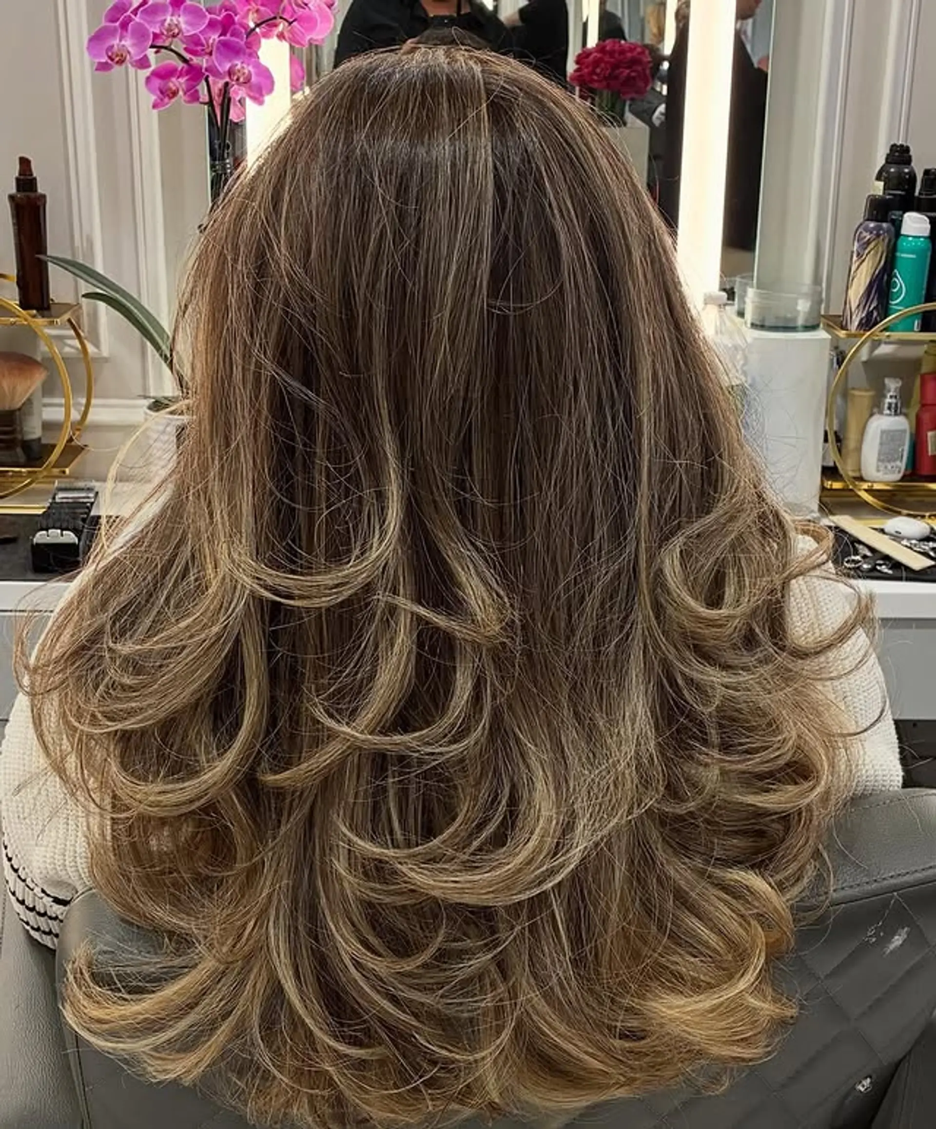 Long, layered hairstyle with soft, dimensional curls and waves. 1