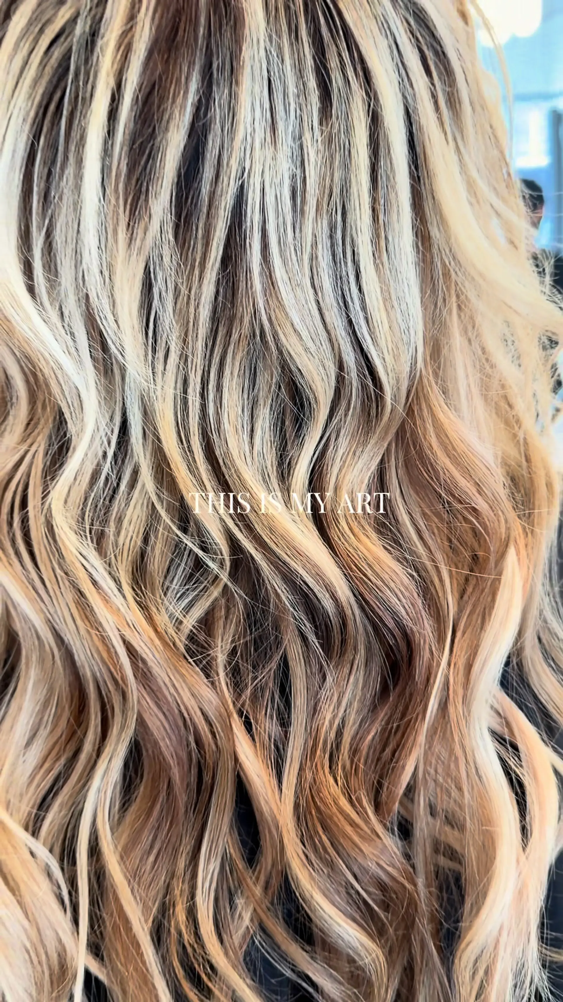 Multi-dimensional blonde highlights and lowlights styled in loose, textured waves. 1