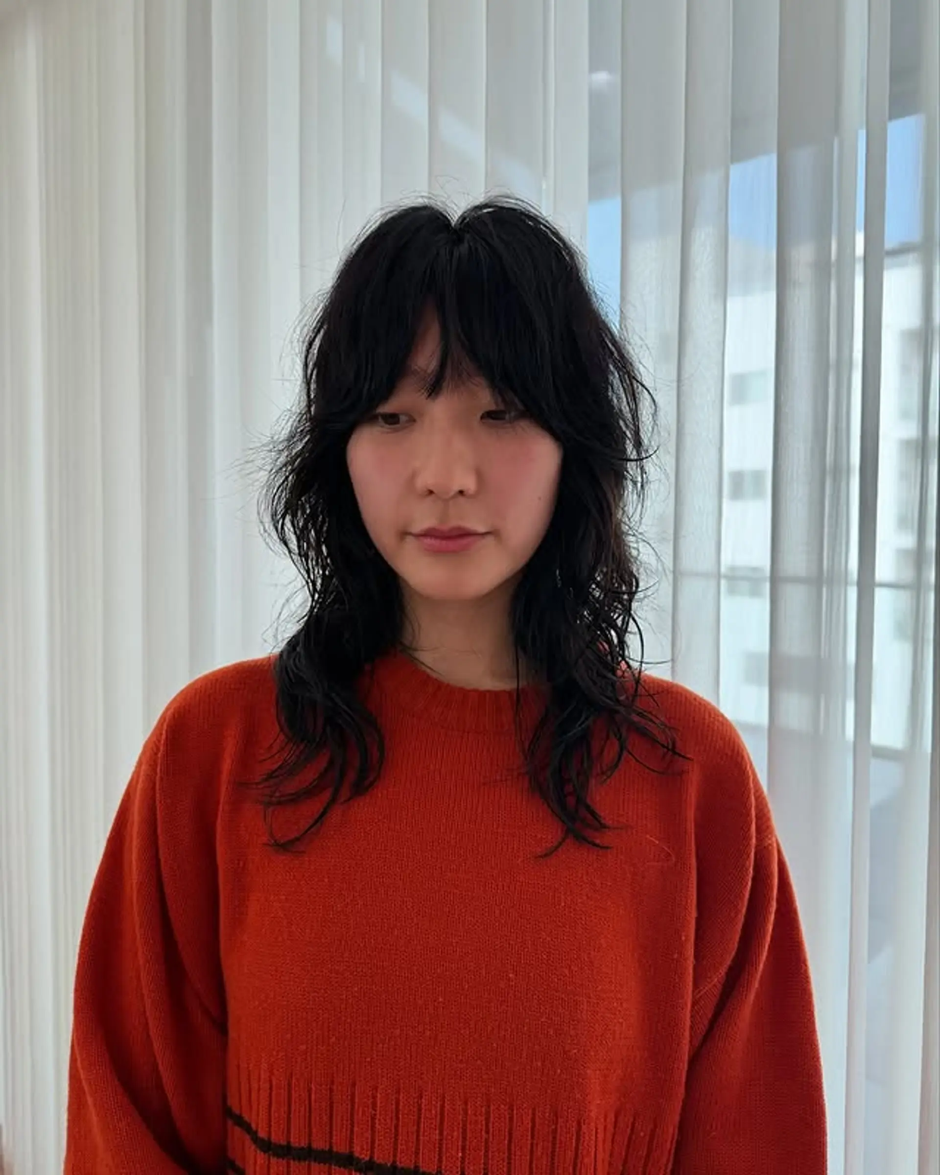 A trendy shag haircut with face-framing curtain bangs and soft layers. 1