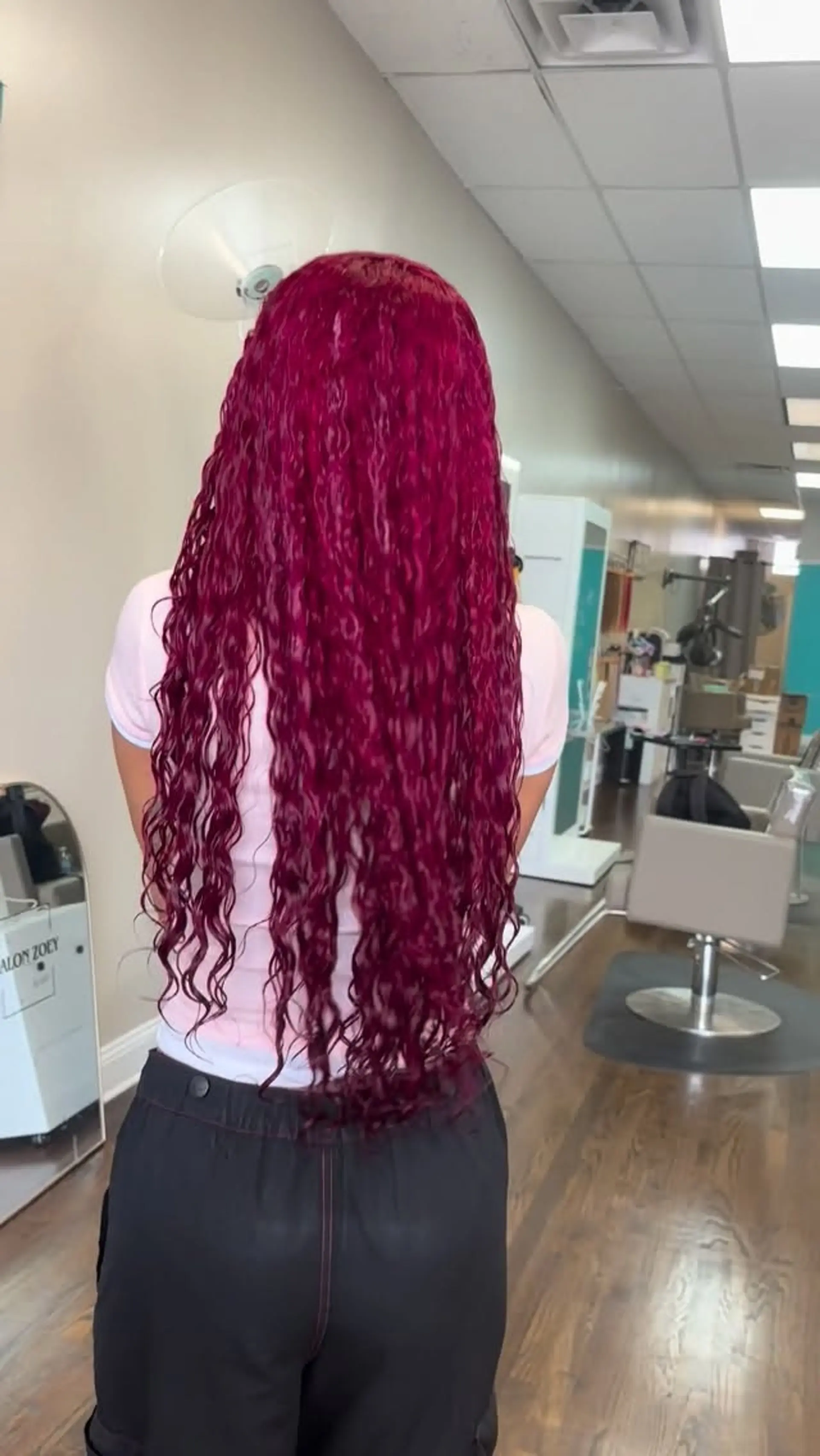 Extra-long hair dyed an intense magenta-ruby shade styled in defined, crimped wet-look waves cascading down the back. 1