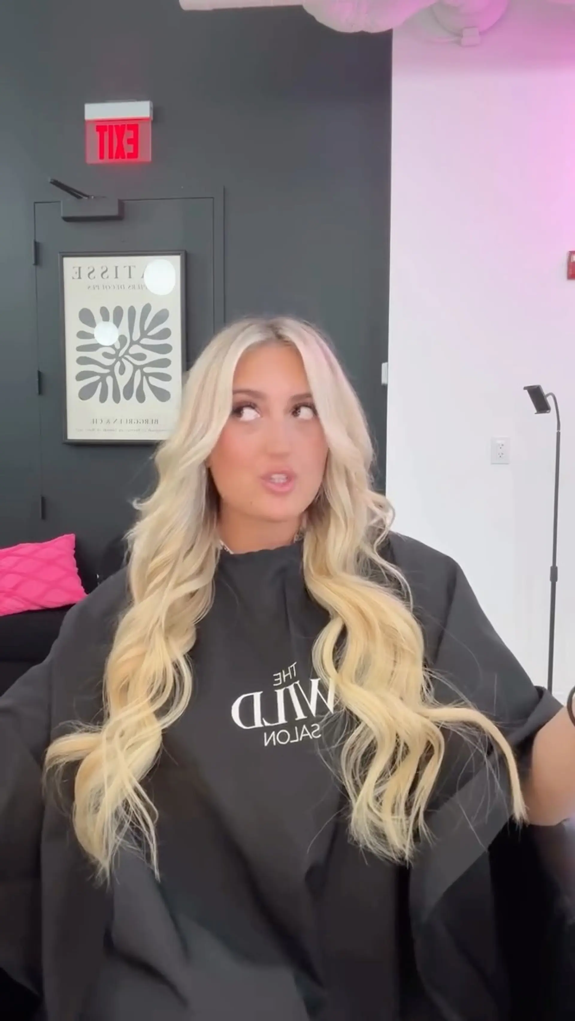 Long bright blonde hair parted in the middle and styled into soft, flowing loose waves with face-framing layers. 1