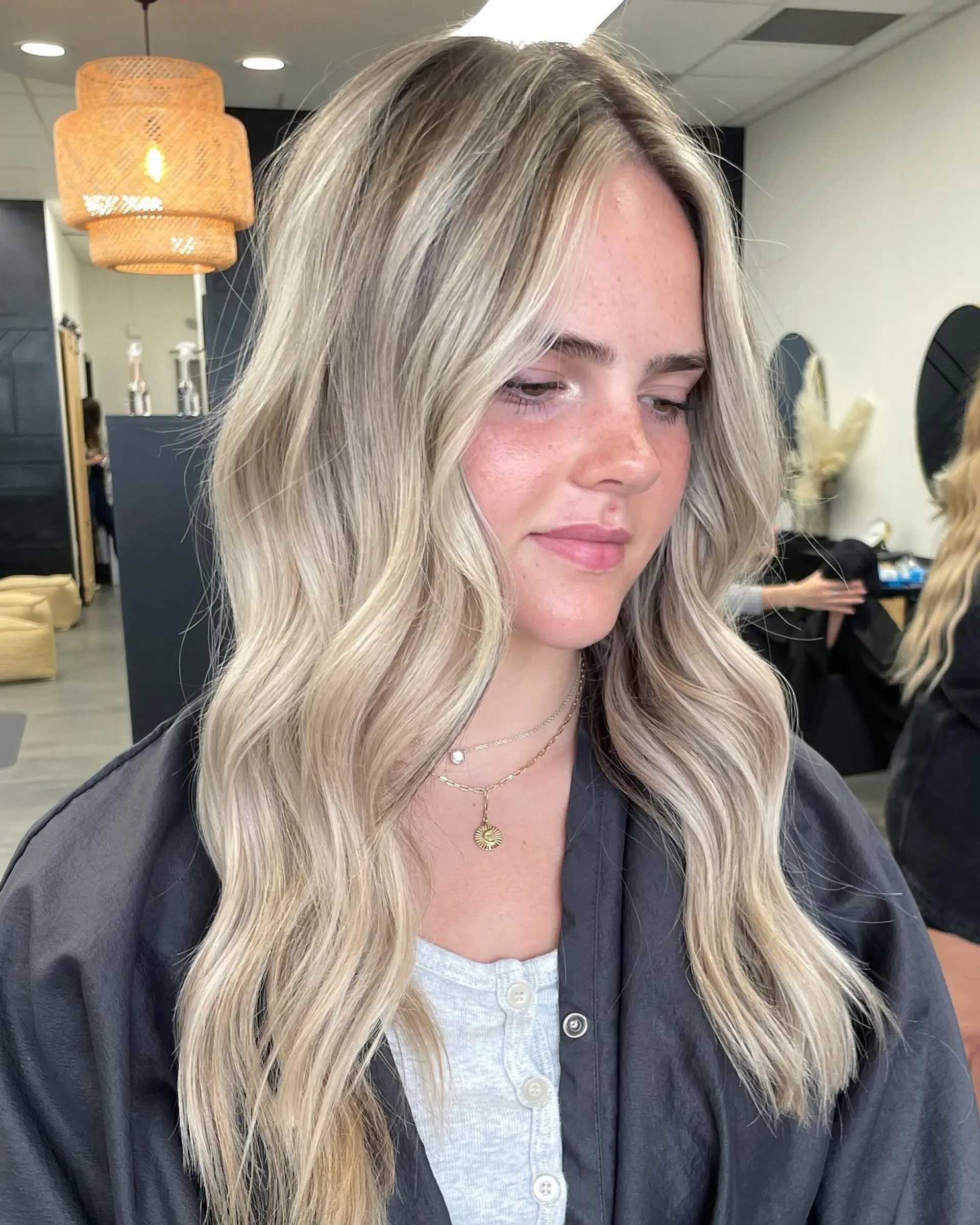 Long beige blonde hair with a blended root melt and soft, dimensional waves. 1