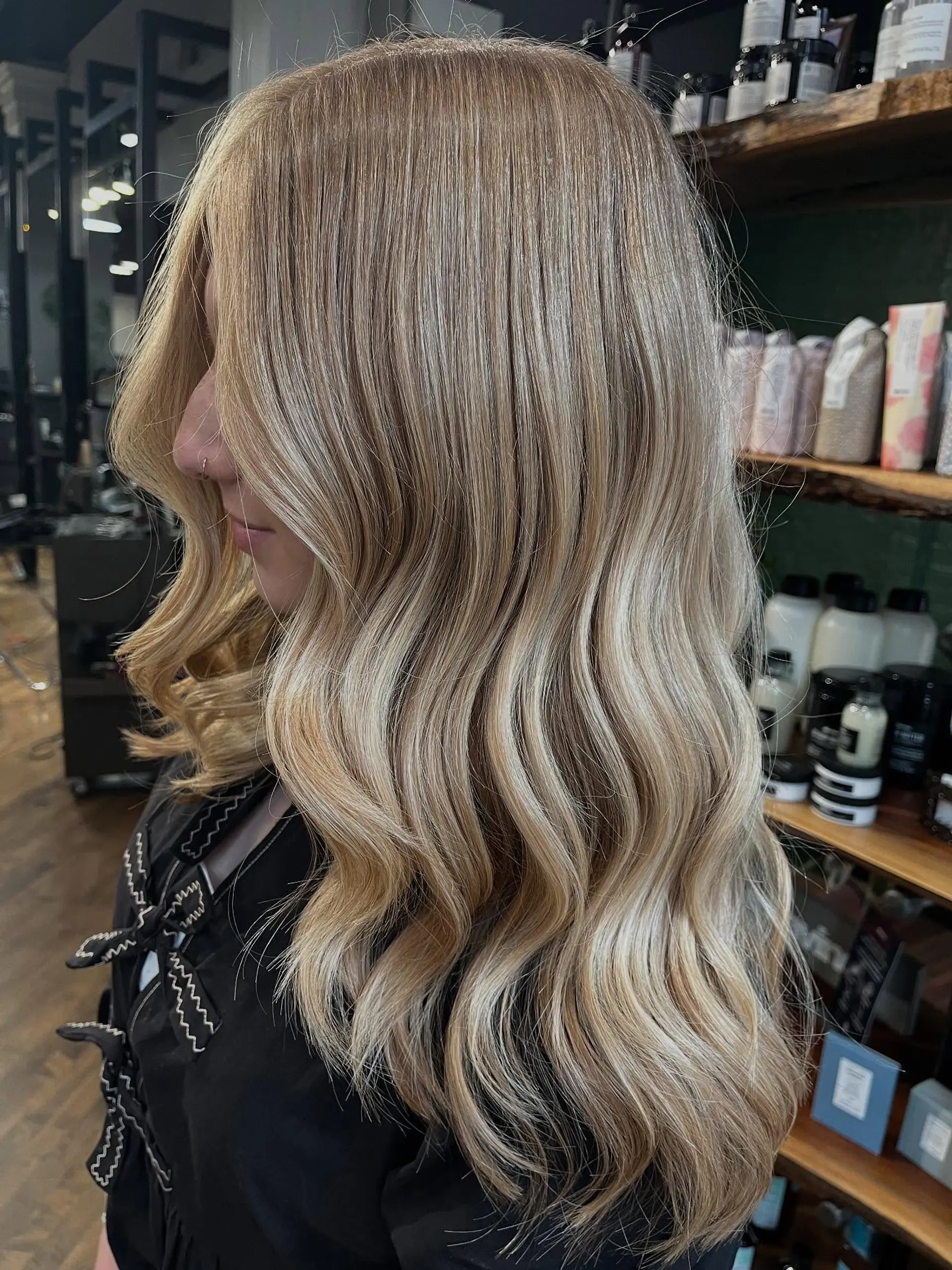 Long blonde hair enhanced with fine dimensional highlights and styled in soft, loose waves. 1