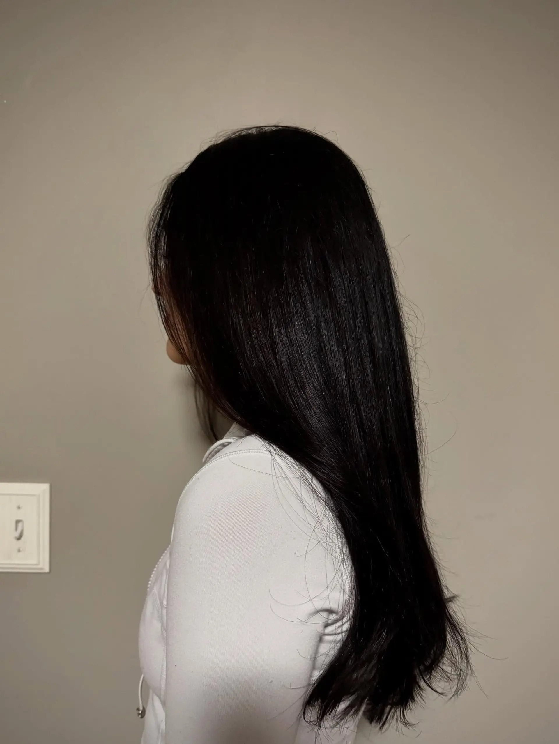 Long, glossy straight dark hair cut with soft, subtle layers and a smooth finish. 1