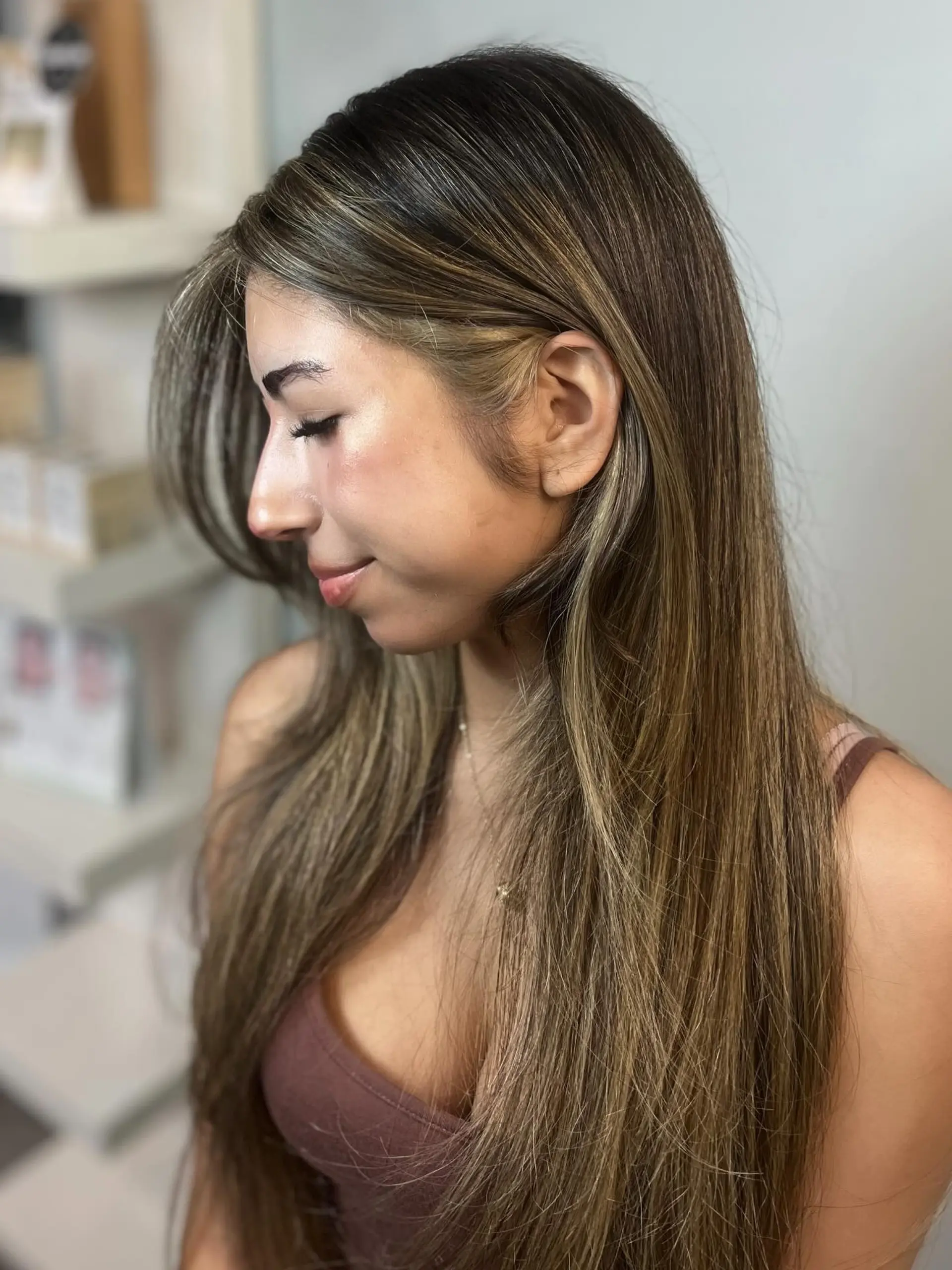 Long, sleek hair enhanced with multidimensional honey and golden blonde balayage highlights and soft face-framing layers. 1