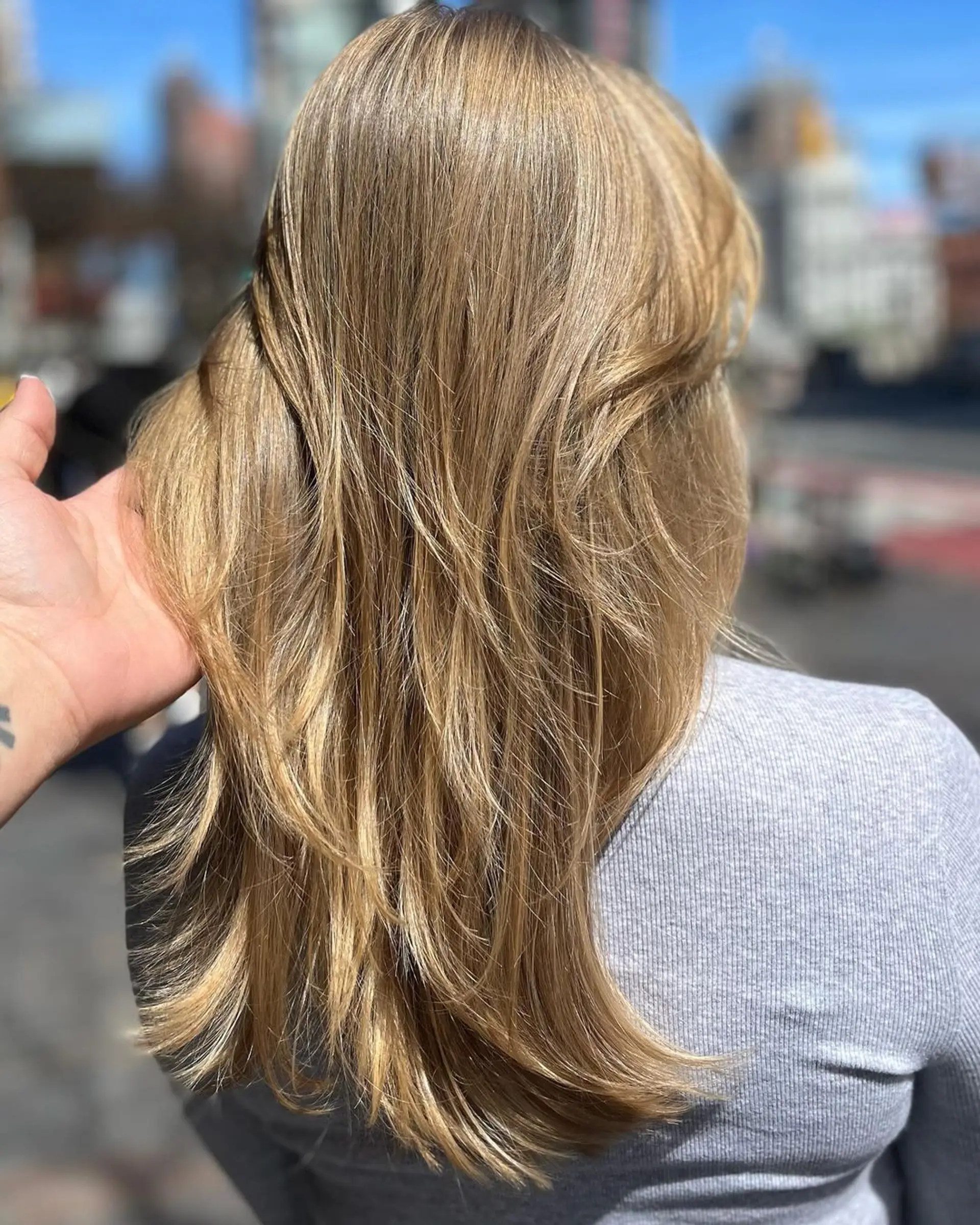 Medium-length, straight, blonde hair with layered, feathered ends and side bangs that blend into the style. 3