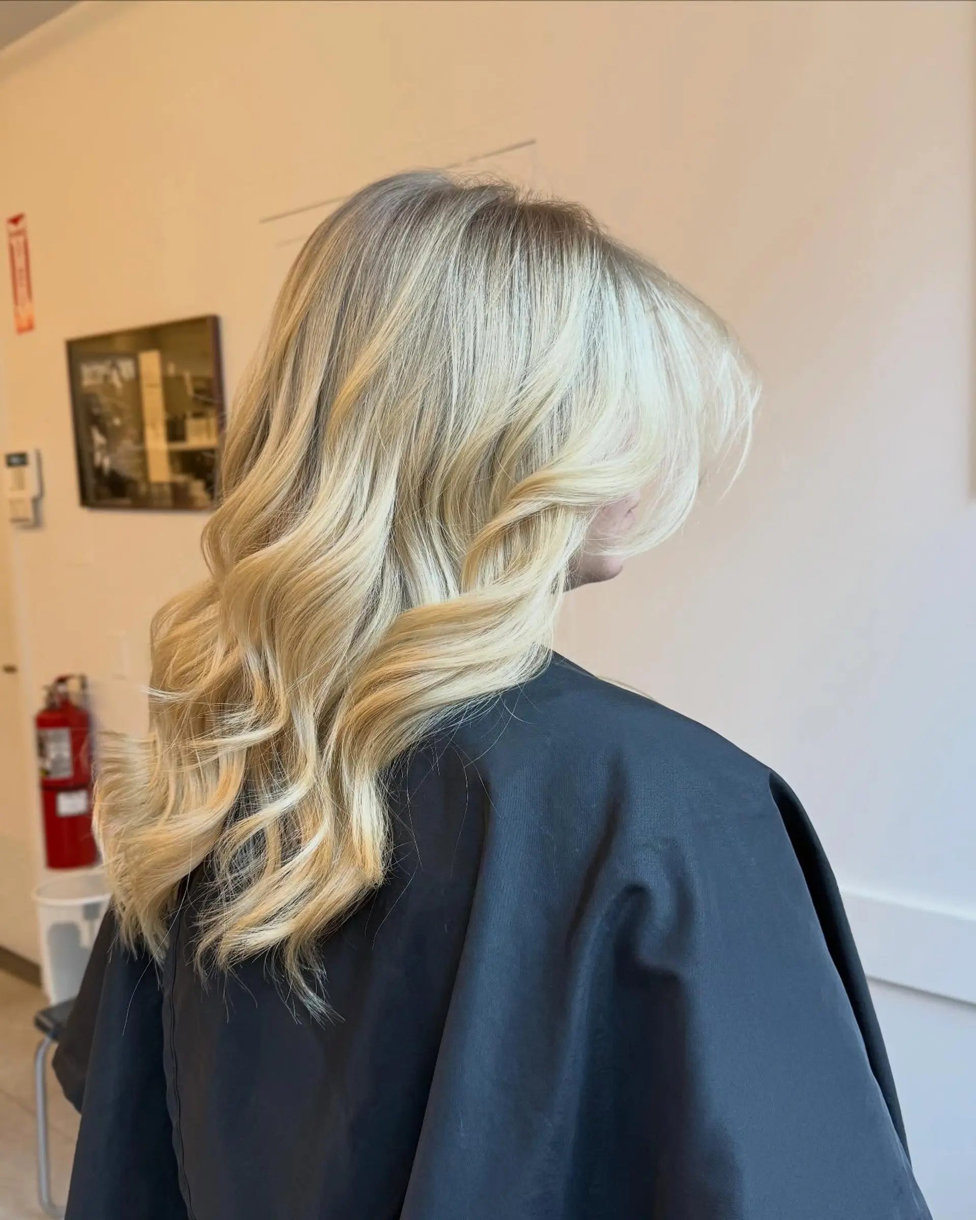 Long hair styled in soft waves with dimensional blonde highlights and face-framing layers. 1