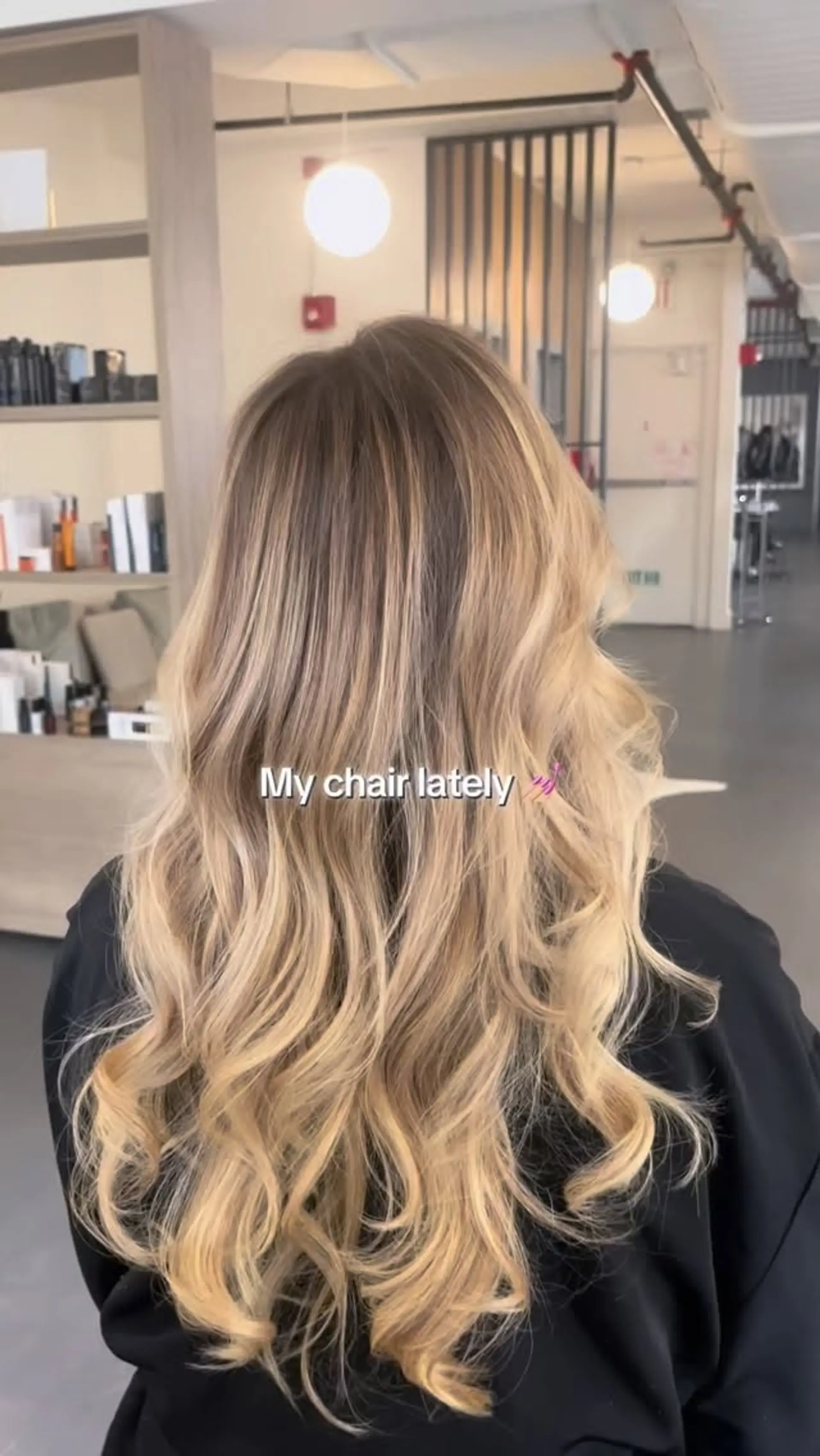 Long layered hair featuring a soft, sun-kissed blonde balayage styled with voluminous loose waves. 1