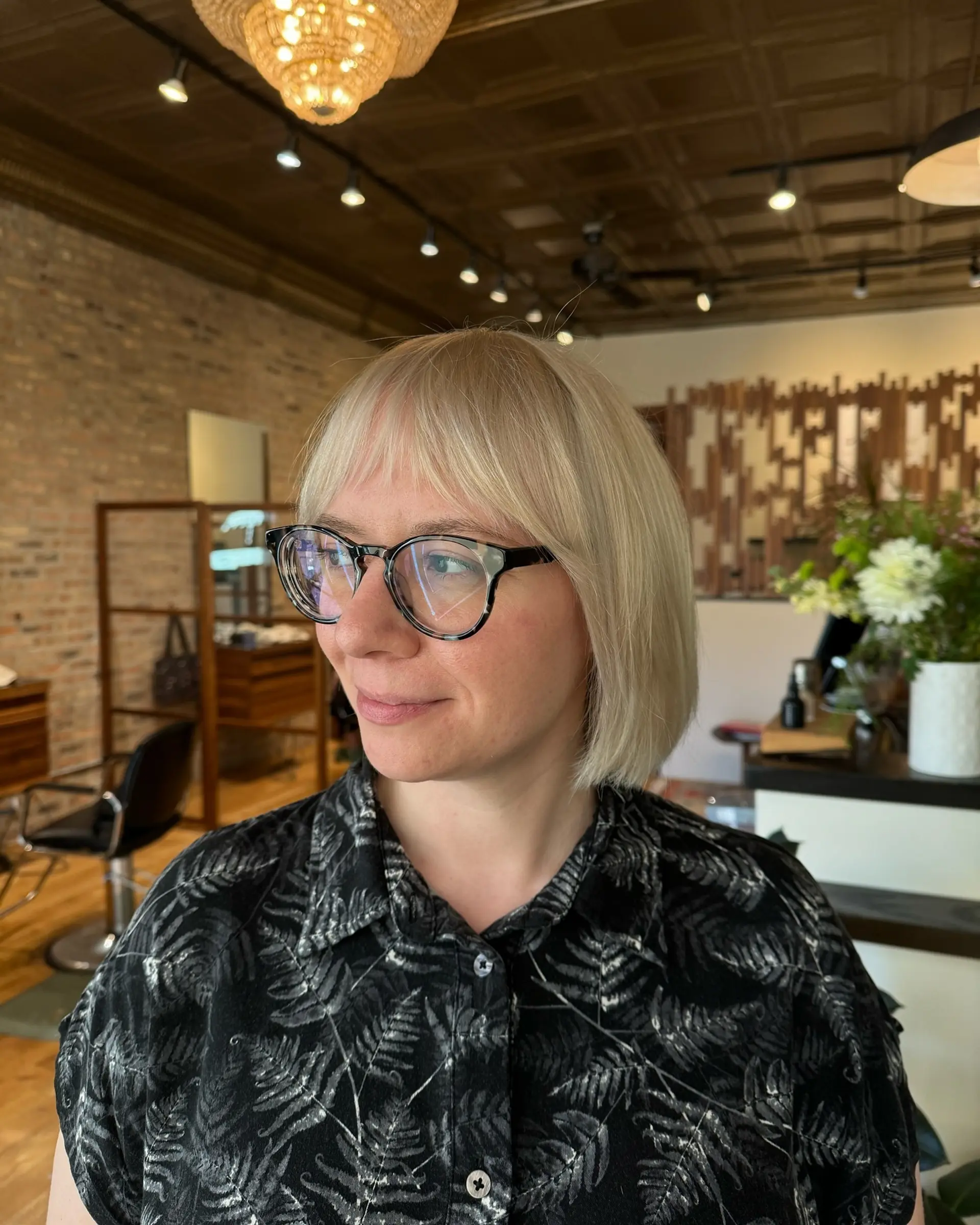 A short, blunt bob with straight bangs, styled in a sleek, modern way. 1