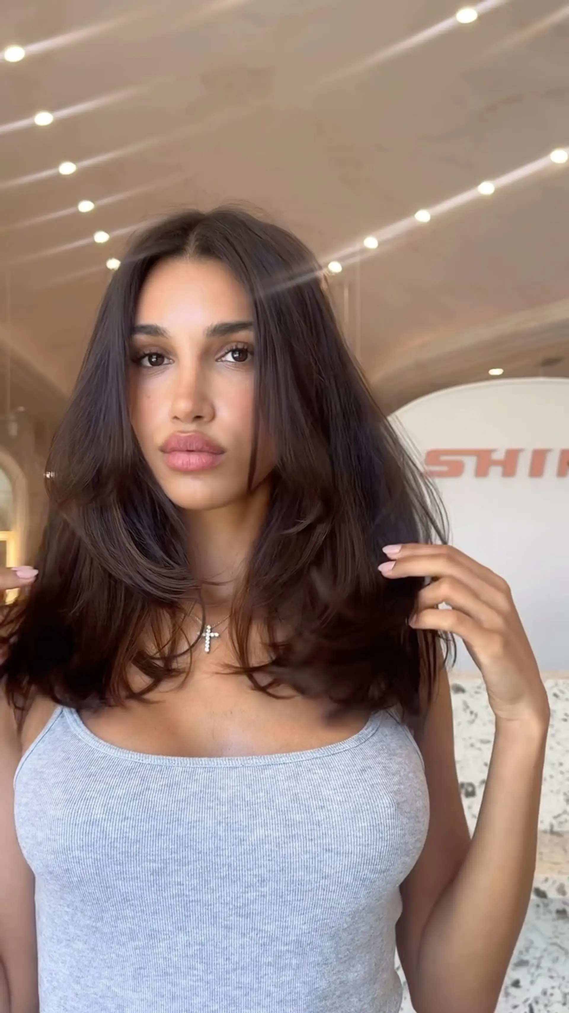 Medium-length dark brown hair cut with soft face-framing layers and styled in a smooth, voluminous blowout. 1