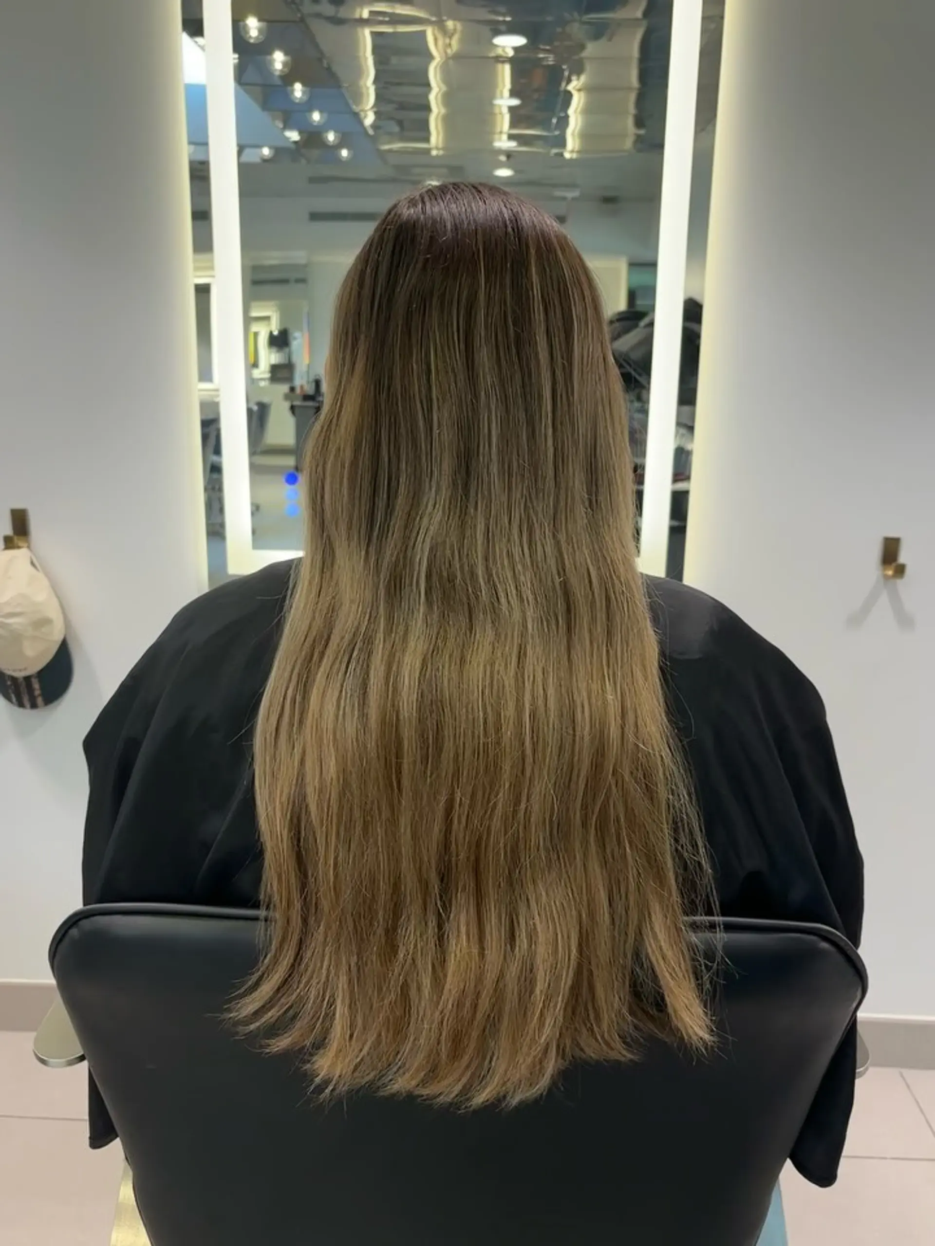 Long hair featuring a seamless transition from a deeper brown base into warm caramel and golden blonde balayage highlights. 1