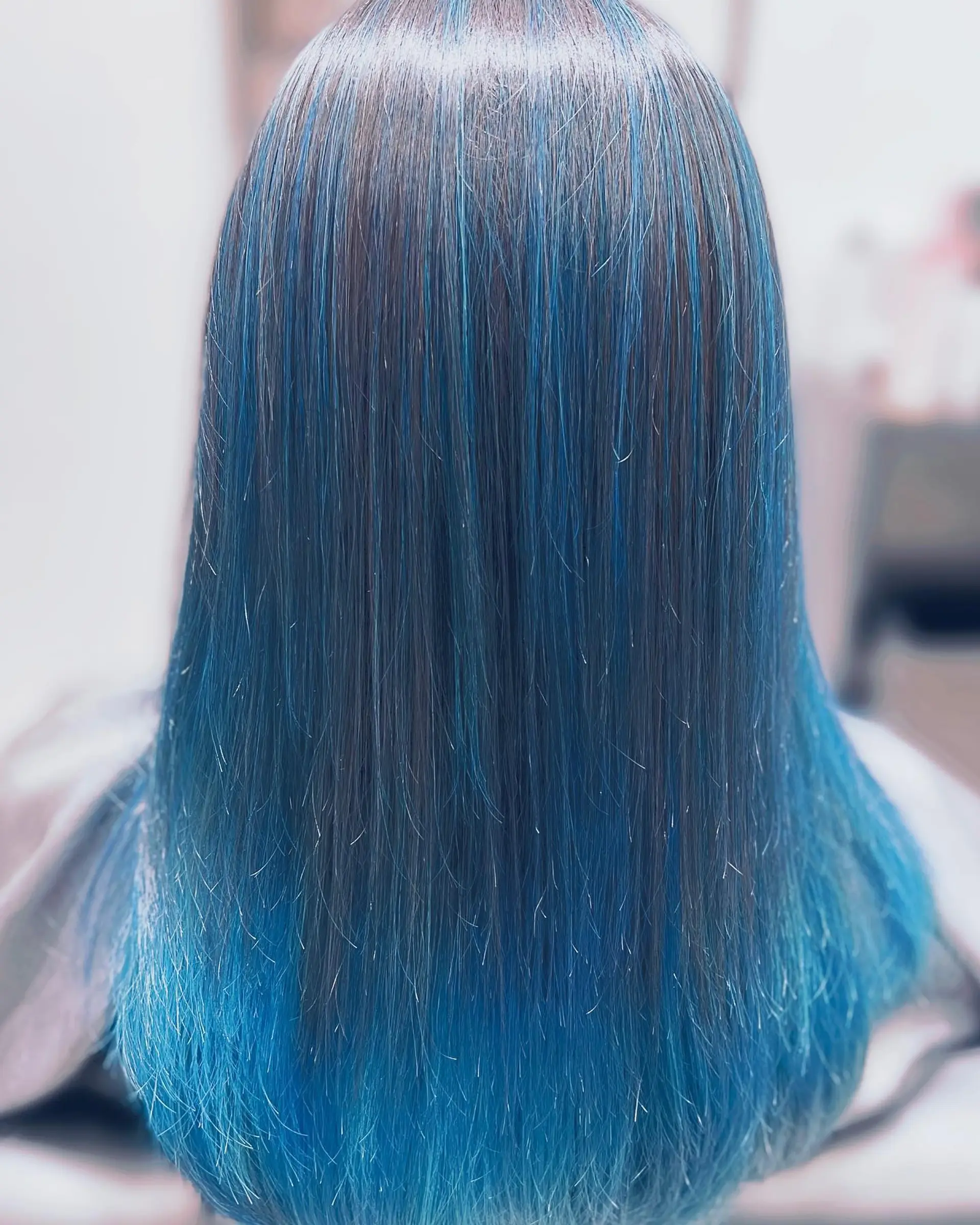 Long, straight hair with a color melt from natural dark roots to a vibrant ocean blue. 1