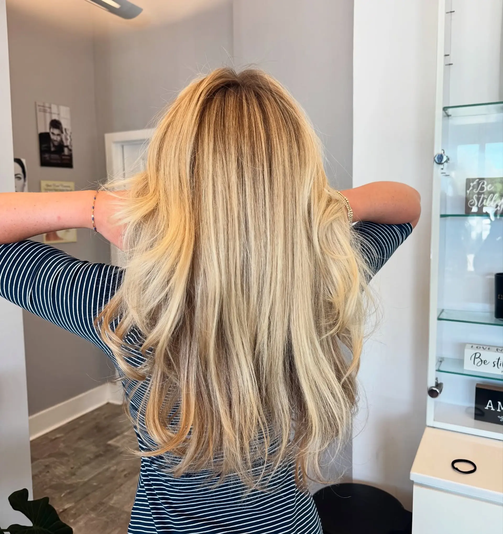 A long, layered haircut with face-framing layers and curtain bangs. The hair is styled with a soft wave. 3