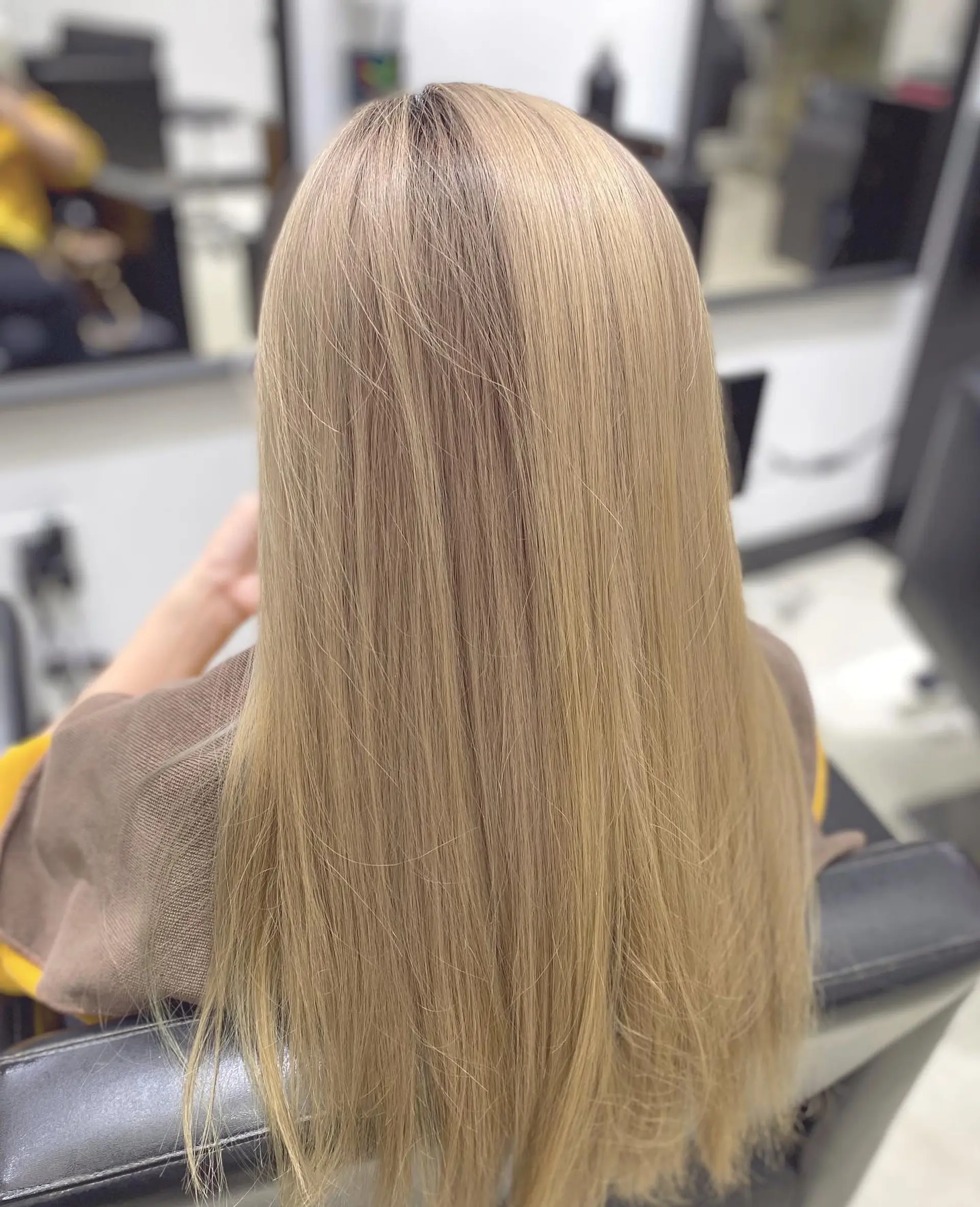 A classic long and straight hairstyle with a modern honey blonde color and intentionally visible roots. 1