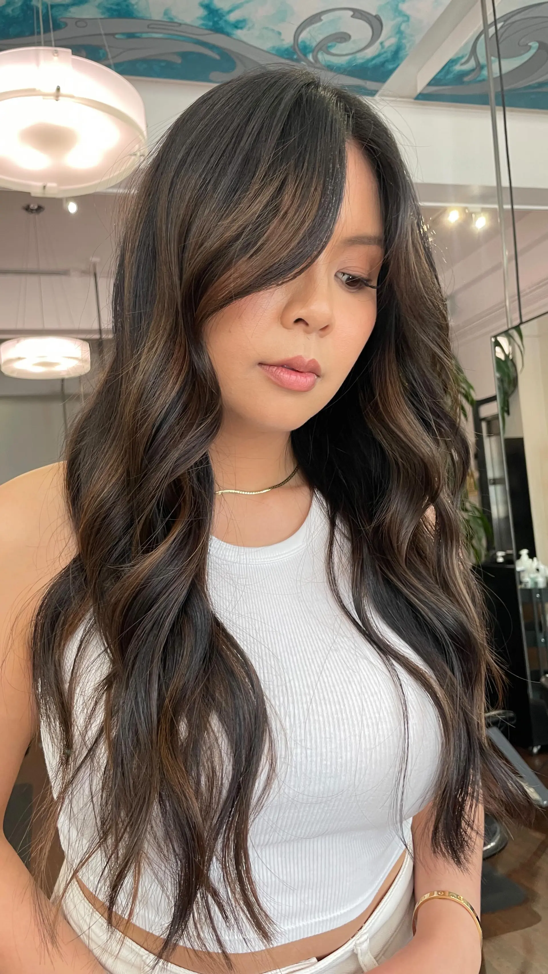 Long chocolate brown hair styled with voluminous loose waves and sweeping face-framing layers. 1