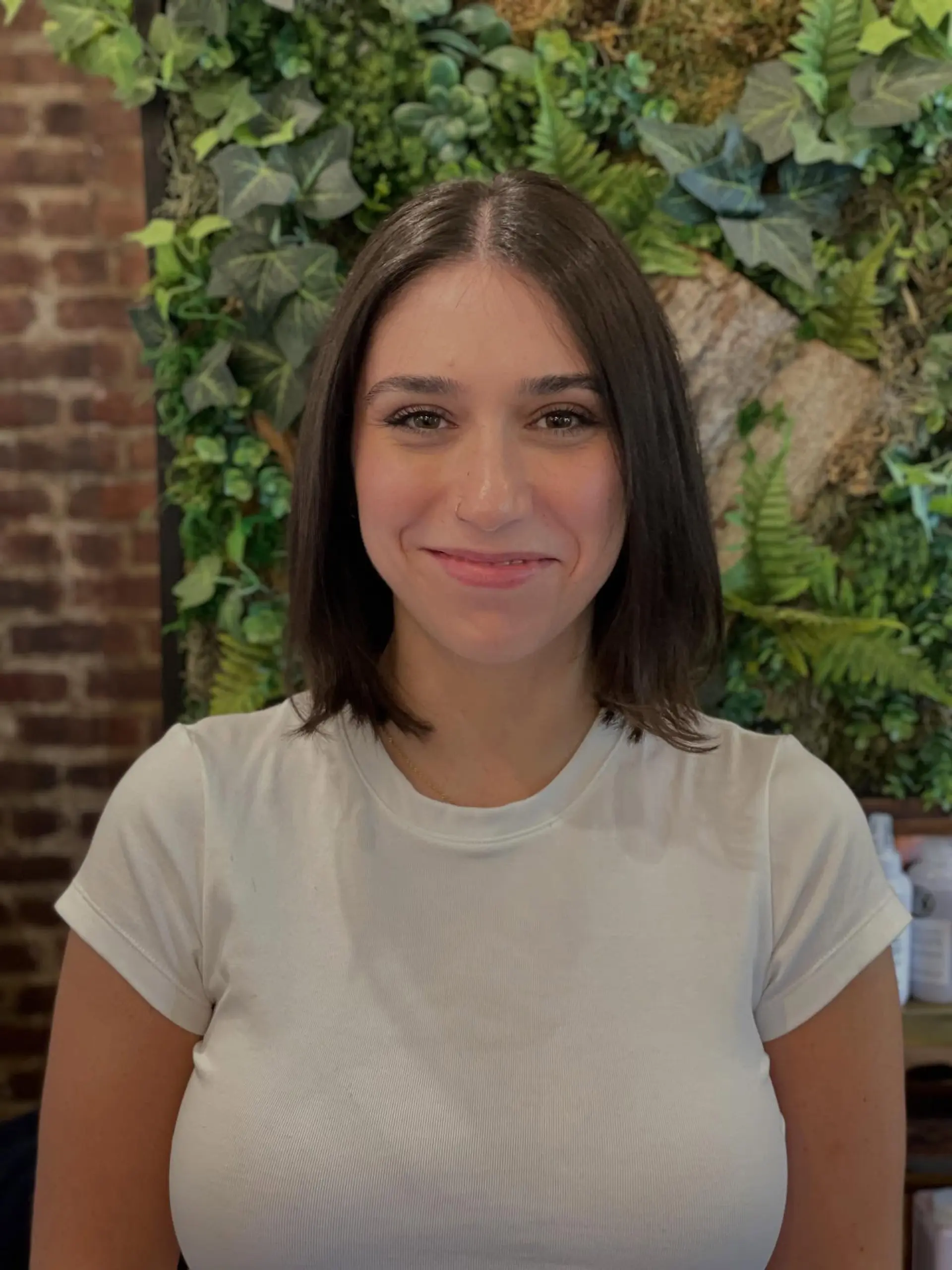 A sleek, shoulder-grazing brunette bob cut with a clean center part and softly textured ends. 1