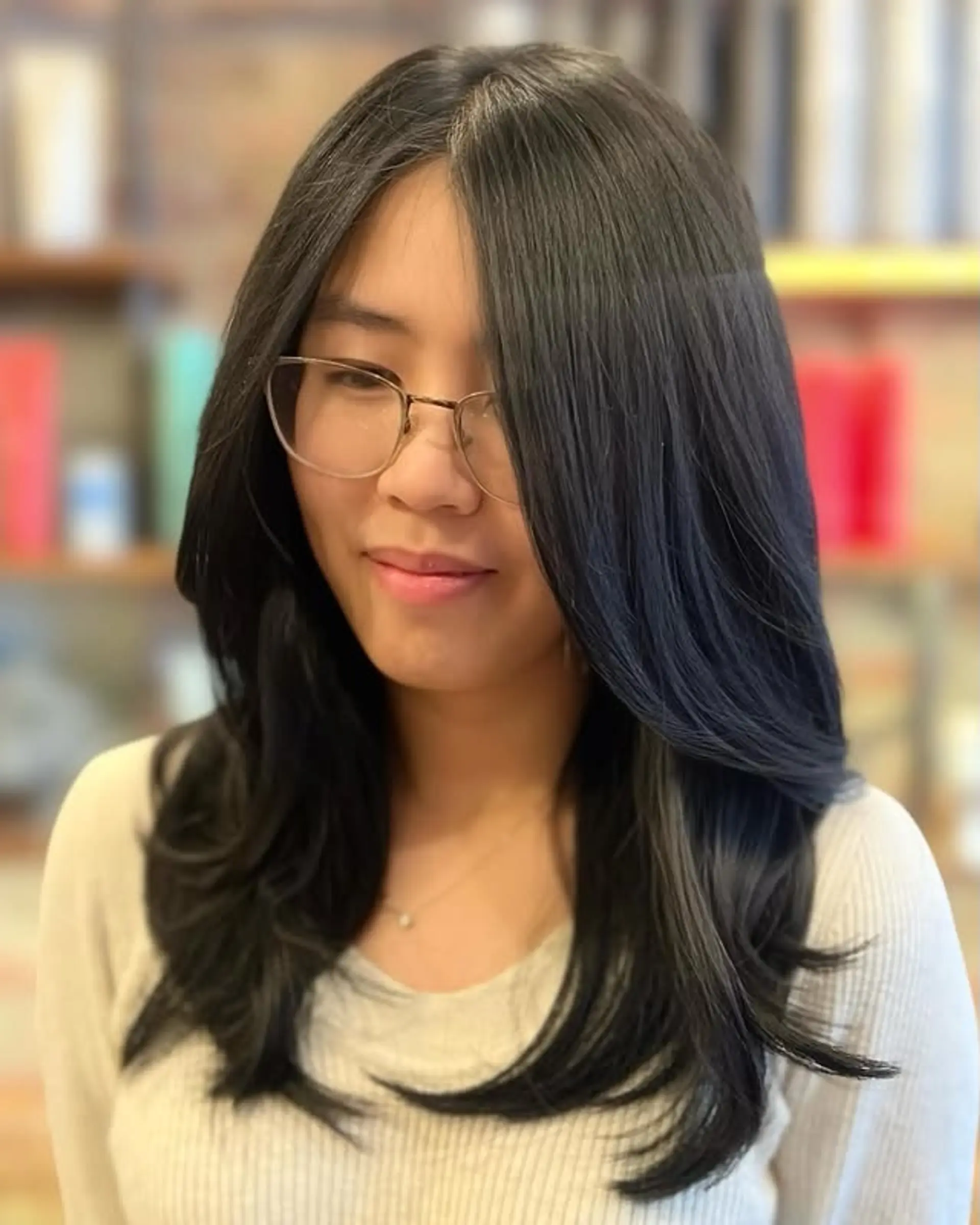 A layered hairstyle with face-framing layers and curtain bangs, also known as the butterfly cut. 1