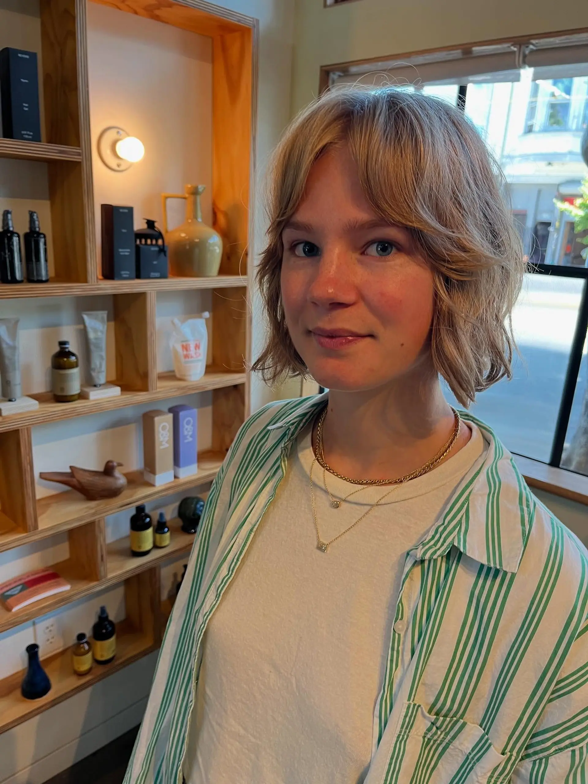 Short textured bob with soft curtain bangs and natural wave. 1