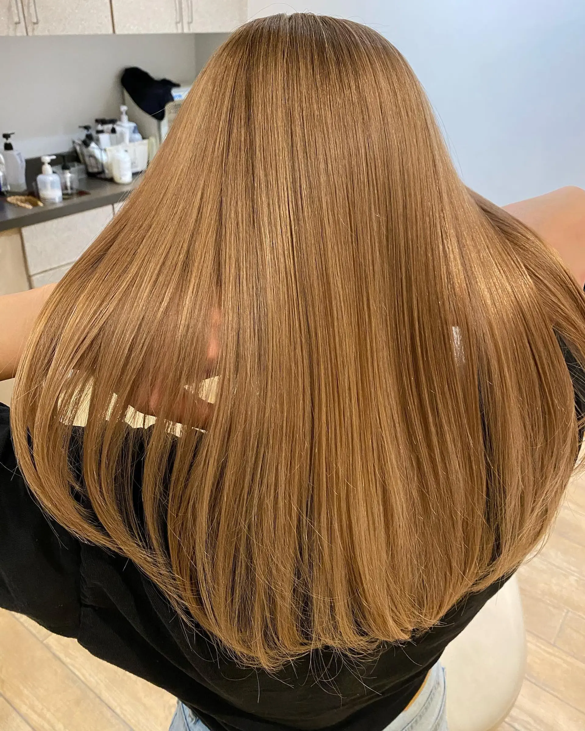 Straight, glossy long hair colored in a smooth milk tea blonde hue. 1
