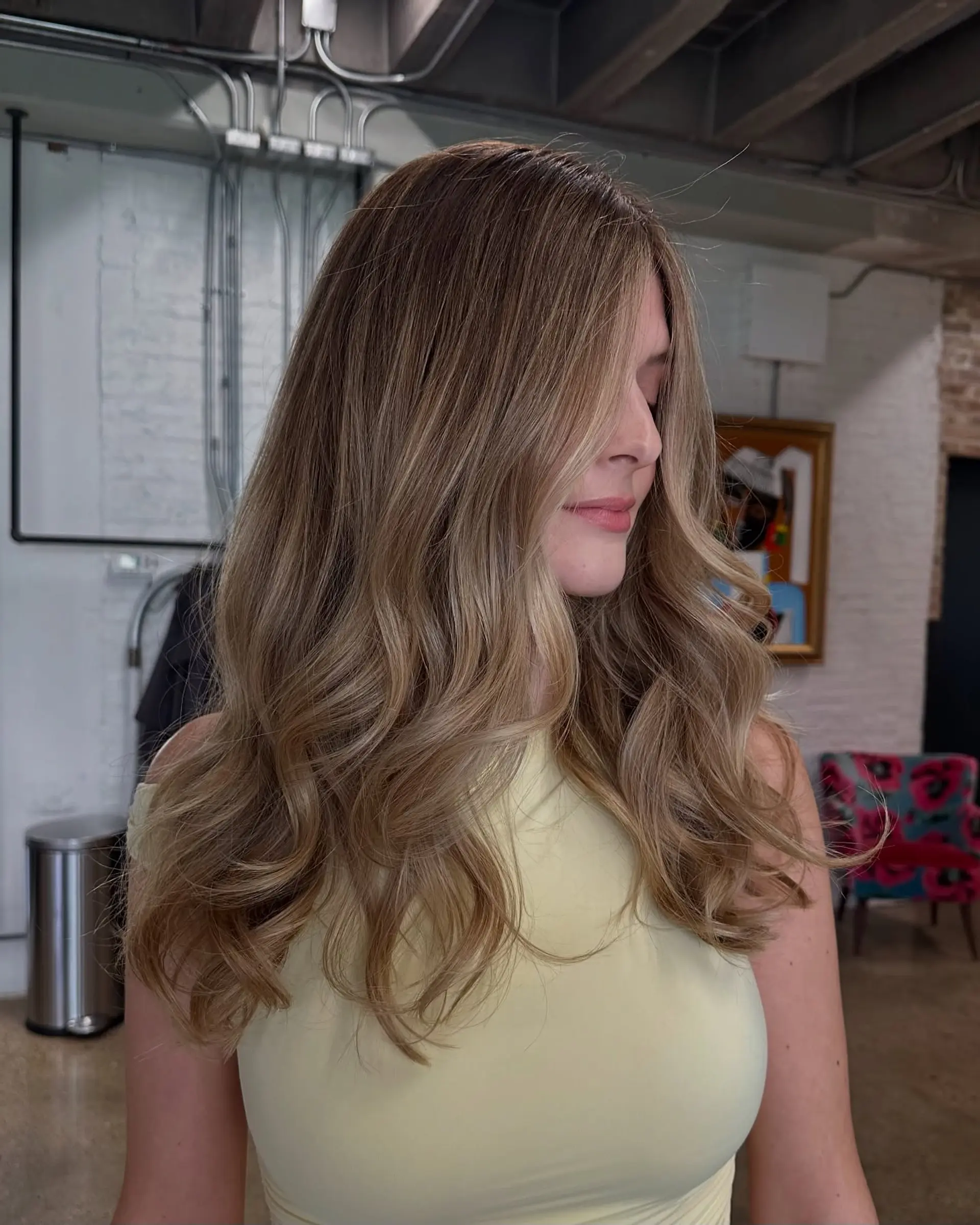 Long bronde hair with beachy waves achieved through a balayage technique. 1