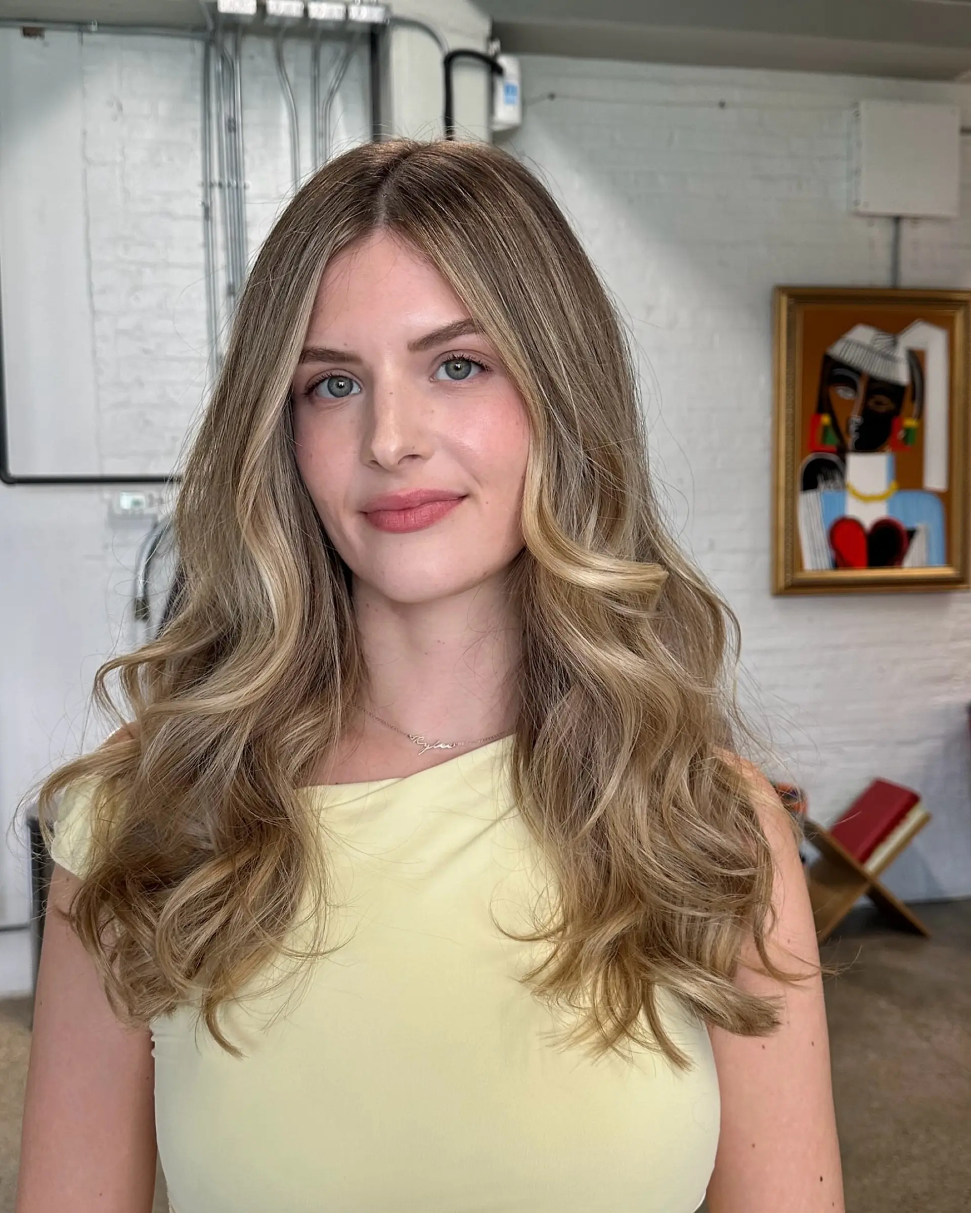 Long bronde hair with beachy waves achieved through a balayage technique. 2