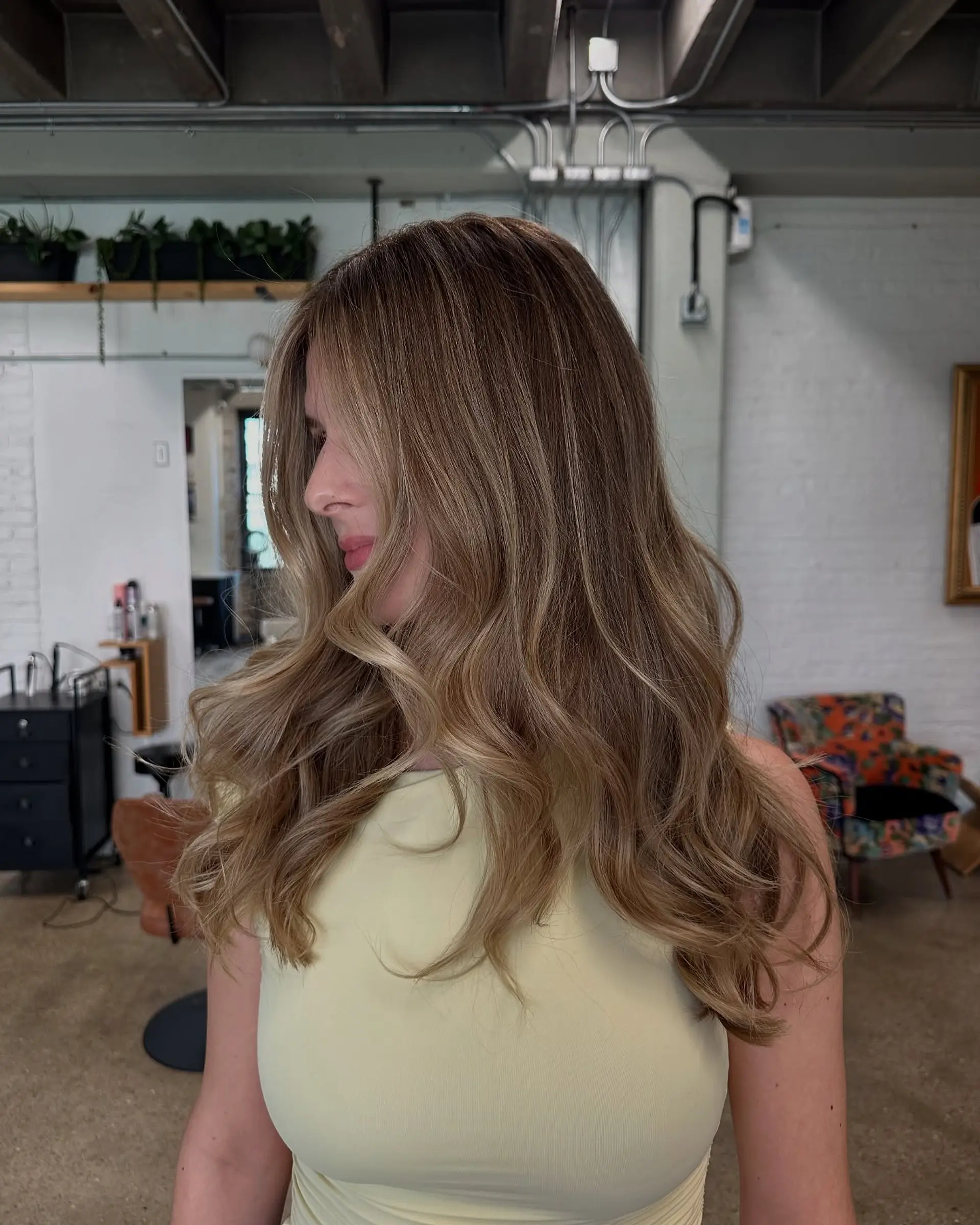 Long bronde hair with beachy waves achieved through a balayage technique. 5