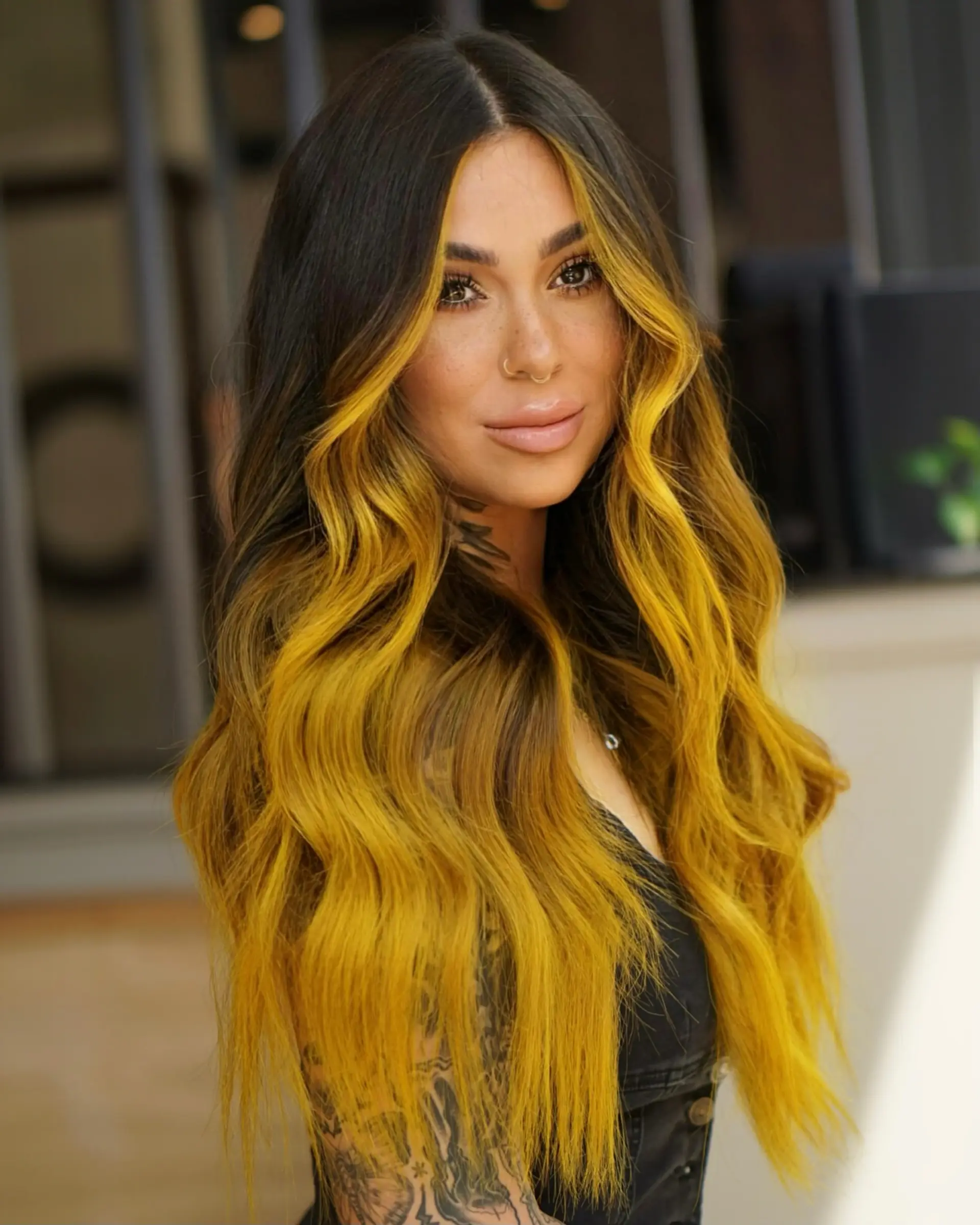 Very long, dark brown hair styled in soft waves, featuring a high-contrast warm mustard yellow balayage and bold face-framing money piece highlights. 1