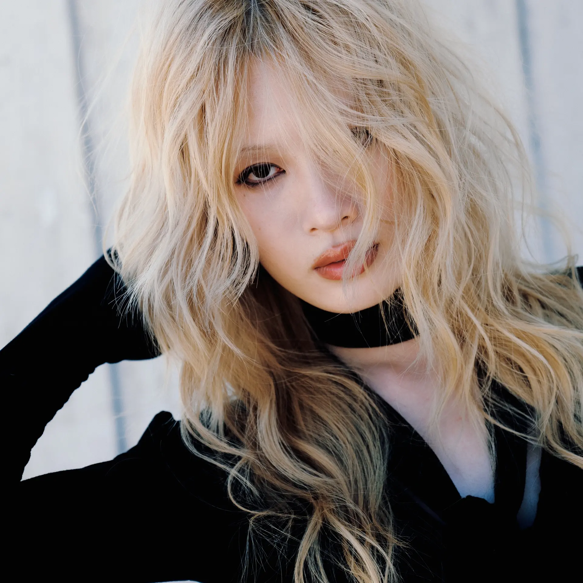 Tousled and heavily layered light blonde hair styled with wispy, face-framing strands falling across the face. 1