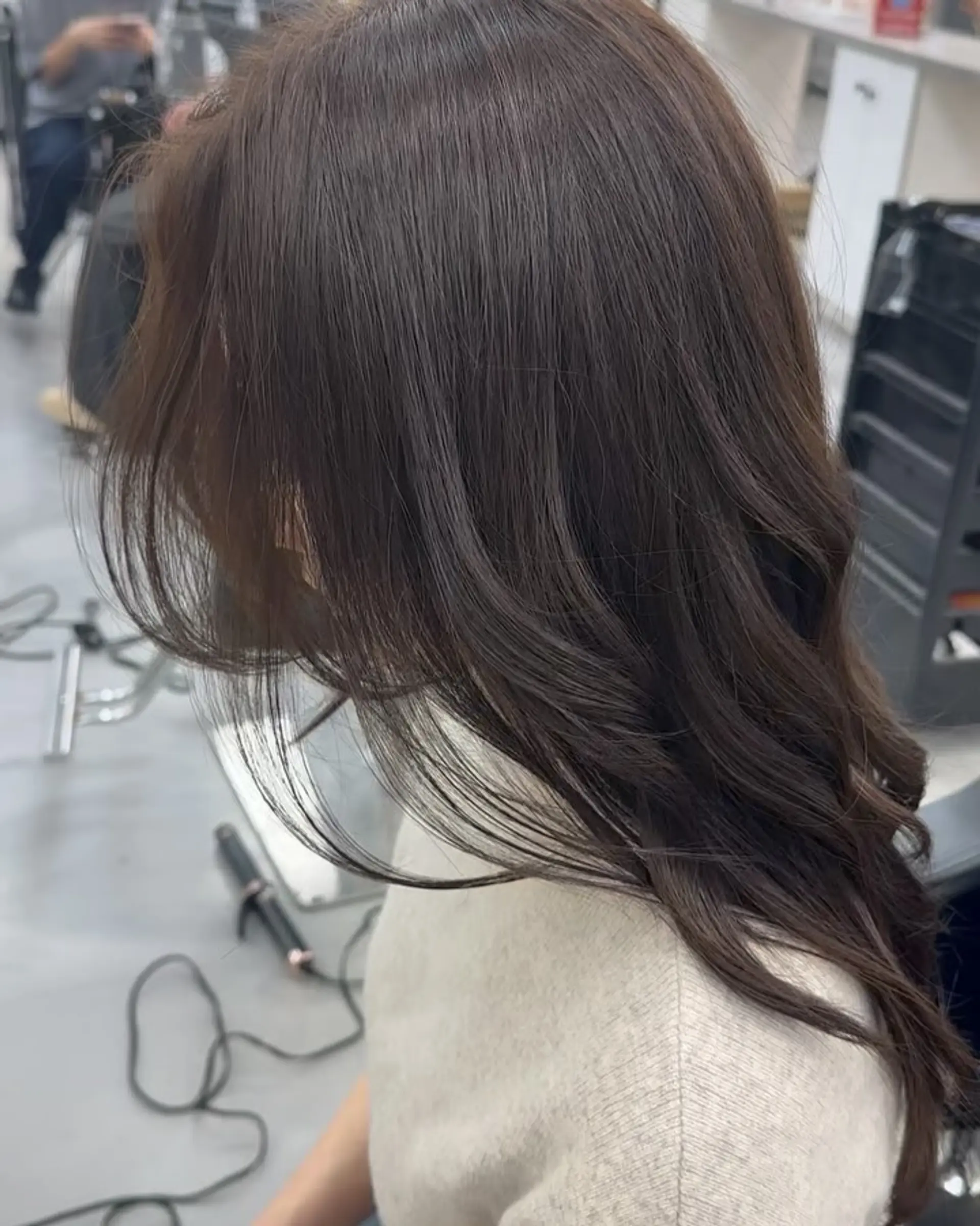 Long rich dark brown hair styled with soft, cascading waves and face-framing layers. 1