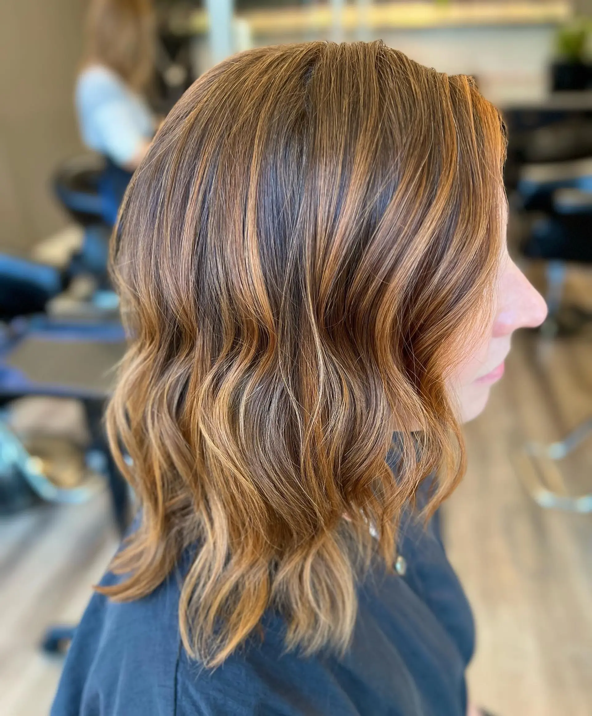 A stylish wavy bob with caramel balayage highlights, cut to a medium length. 1