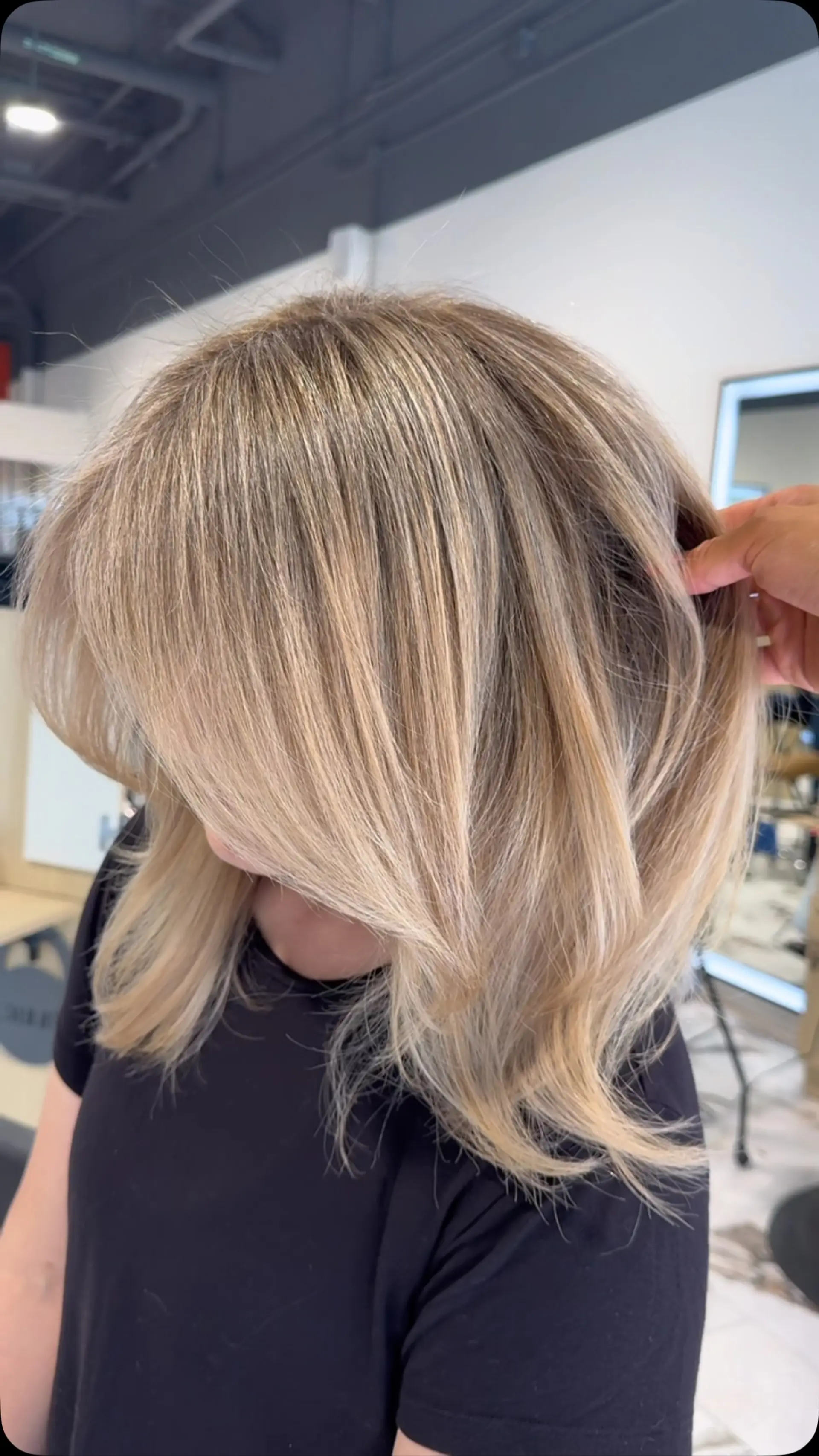 Shoulder-length layered cut styled into a soft blowout with dimensional ash blonde gray-blending highlights. 1
