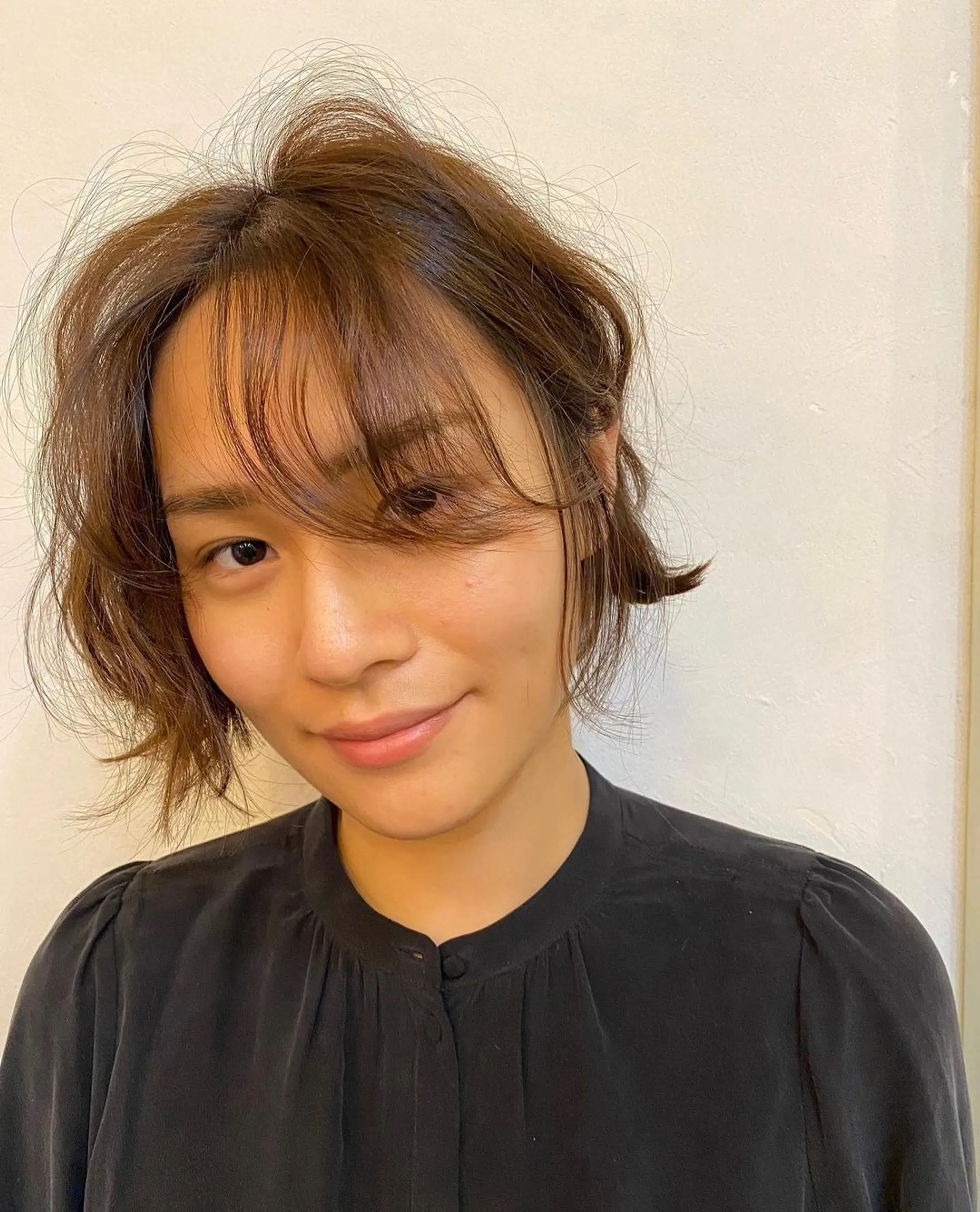 The Messy Chic Bob features a short, wavy cut with a side-swept fringe and a slightly tousled texture, creating a casual and elegant look with natural brown hues. (Hair by Coco) 2