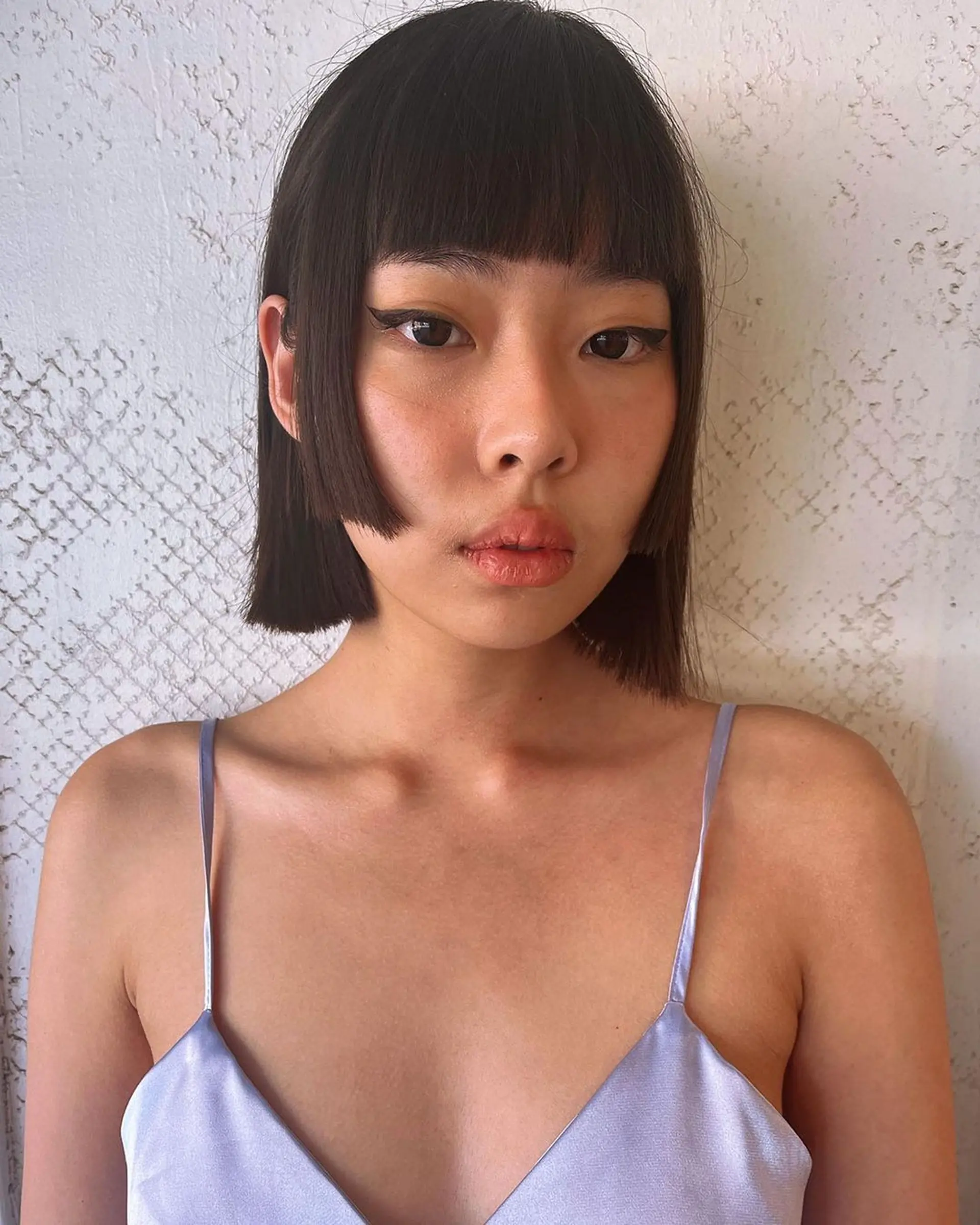 A sleek, short bob with straight dark brown hair cut at chin length, featuring a blunt fringe and symmetrical edges for a modern, glossy look. 1