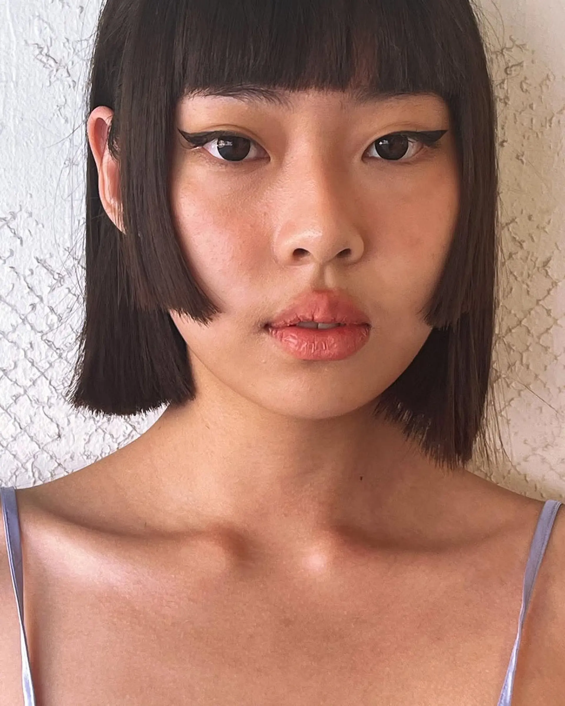 A sleek, short bob with straight dark brown hair cut at chin length, featuring a blunt fringe and symmetrical edges for a modern, glossy look. 2